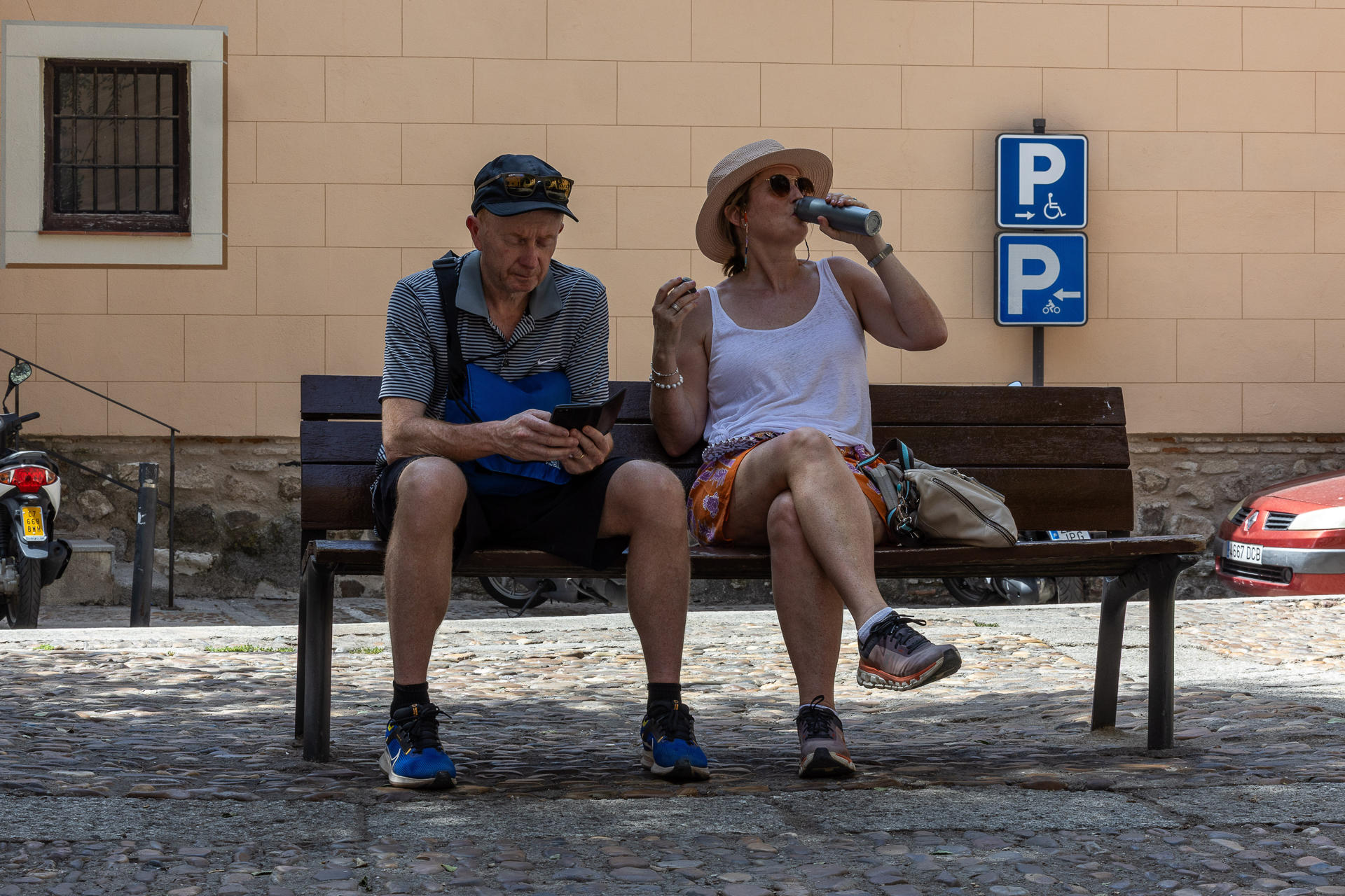 Una mujer bebe agua en un banco a la sombra este viernes en Toledo. EFE/Ismael Herrero
