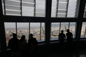 Unas personas observan las vistas de Barcelona desde el Mirador Torre Glòries que acogerá del 2 al 5 de septiembre la 36 edición de la Convención Anual de la World Federation of Great Towers (WFGT), la "Champions League" de las torres más icónicas del mundo, a la que asistirán los representantes de 26 de las 55 torres que forman parte de la federación. EFE/Quique García