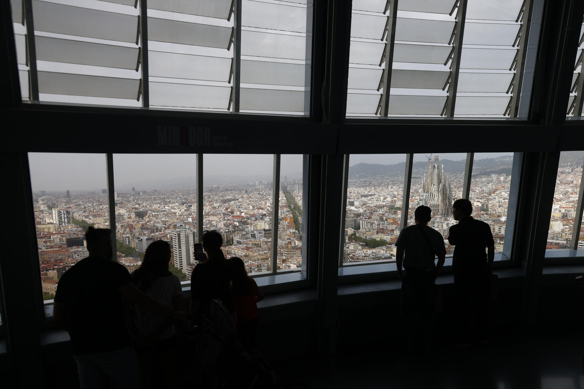 Unas personas observan las vistas de Barcelona desde el Mirador Torre Glòries que acogerá del 2 al 5 de septiembre la 36 edición de la Convención Anual de la World Federation of Great Towers (WFGT), la "Champions League" de las torres más icónicas del mundo, a la que asistirán los representantes de 26 de las 55 torres que forman parte de la federación. EFE/Quique García