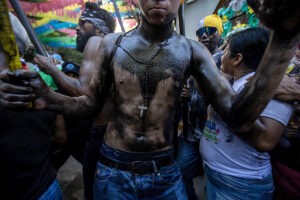 Un joven cubierto de aceite negro participa en la tradición de 'Los Diablitos Negros' durante las fiestas de Santo Domingo este viernes, en Managua (Nicaragua). EFE/ STR