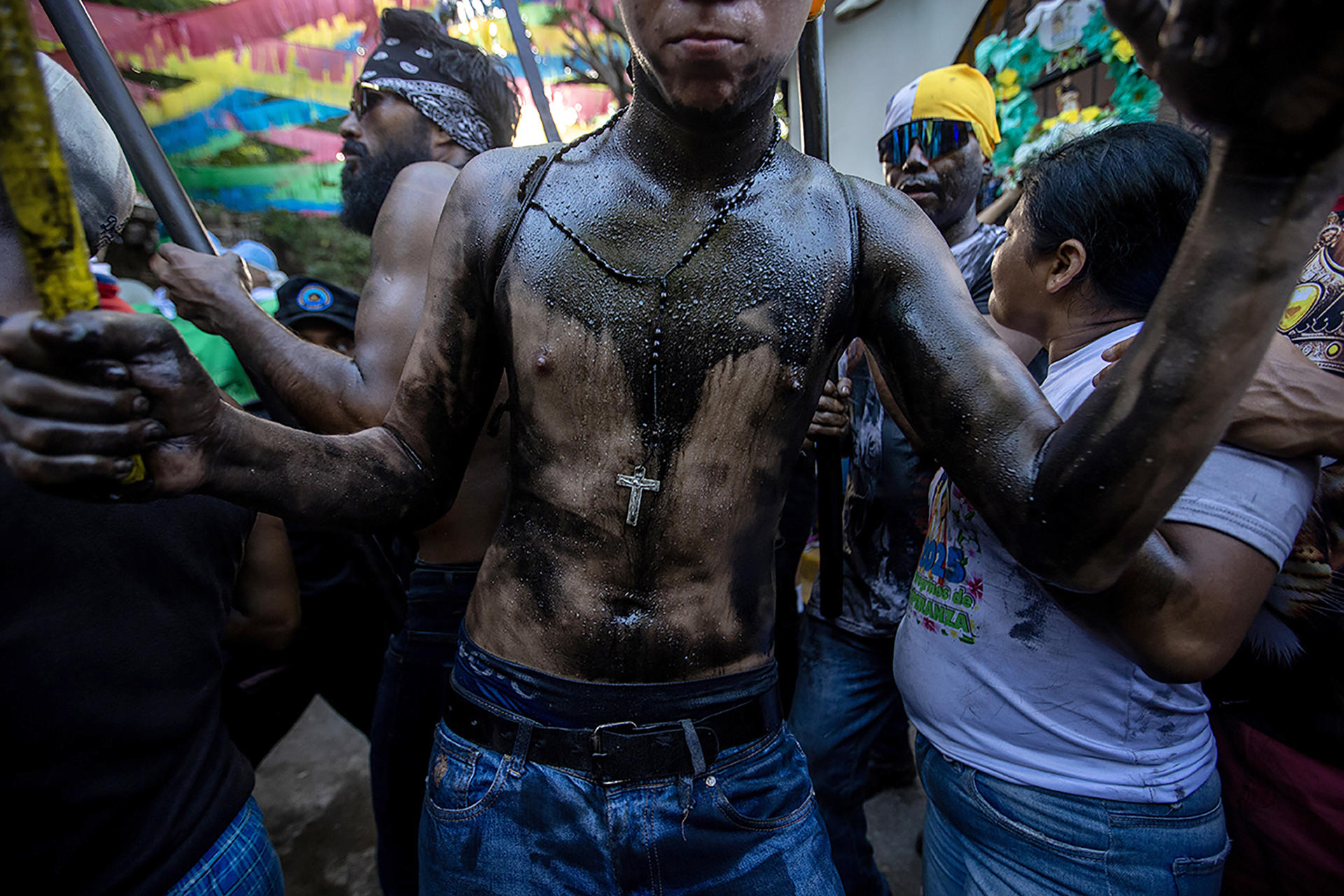 Un joven cubierto de aceite negro participa en la tradición de 'Los Diablitos Negros' durante las fiestas de Santo Domingo este viernes, en Managua (Nicaragua). EFE/ STR