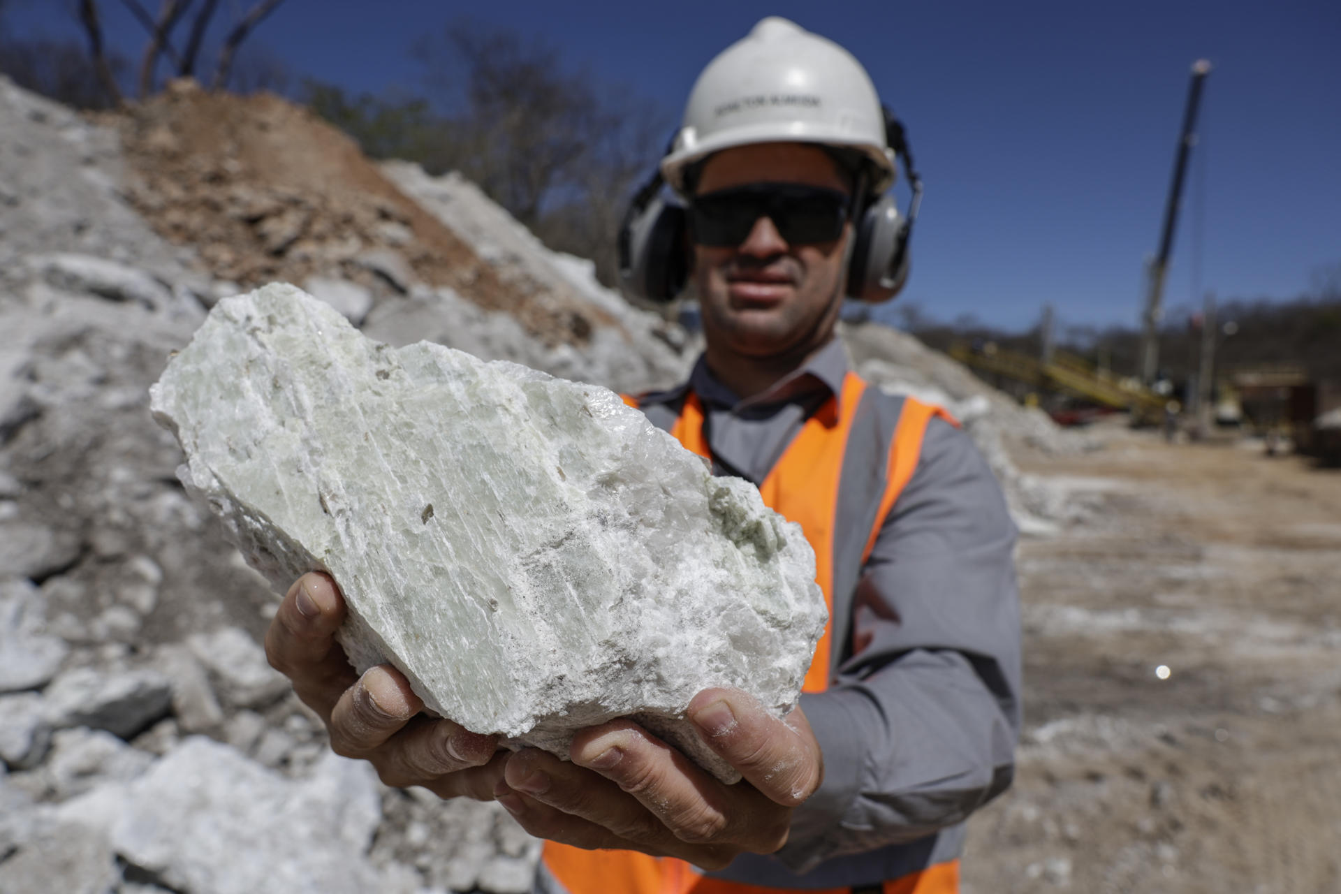 Un empleado muestra una roca con cristales de espodumena en la unidad minera de la Companhia Brasileira de Litio (CBL), el 21 de agosto de 2025 en la ciudad de Araçuaí, Minas Gerais (Brasil). La creciente demanda mundial por litio, el principal componente de las baterías de los vehículos eléctricos, convirtió en un "El Dorado" al Valle del Jequitinhonha, una de las regiones más pobres de Brasil, pero dueña de las séptimas mayores reservas mundiales del mineral. EFE/André Coelho
