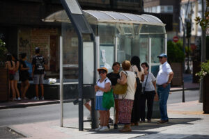 Unas personas esperan a un autobús a la sombra de una parada este miércoles en una terraza de la localidad toledana de Talavera de la Reina, que marcó ayer la temperatura máxima del país, 42,7 grados a las 18:20 horas. EFE/Manu Reino