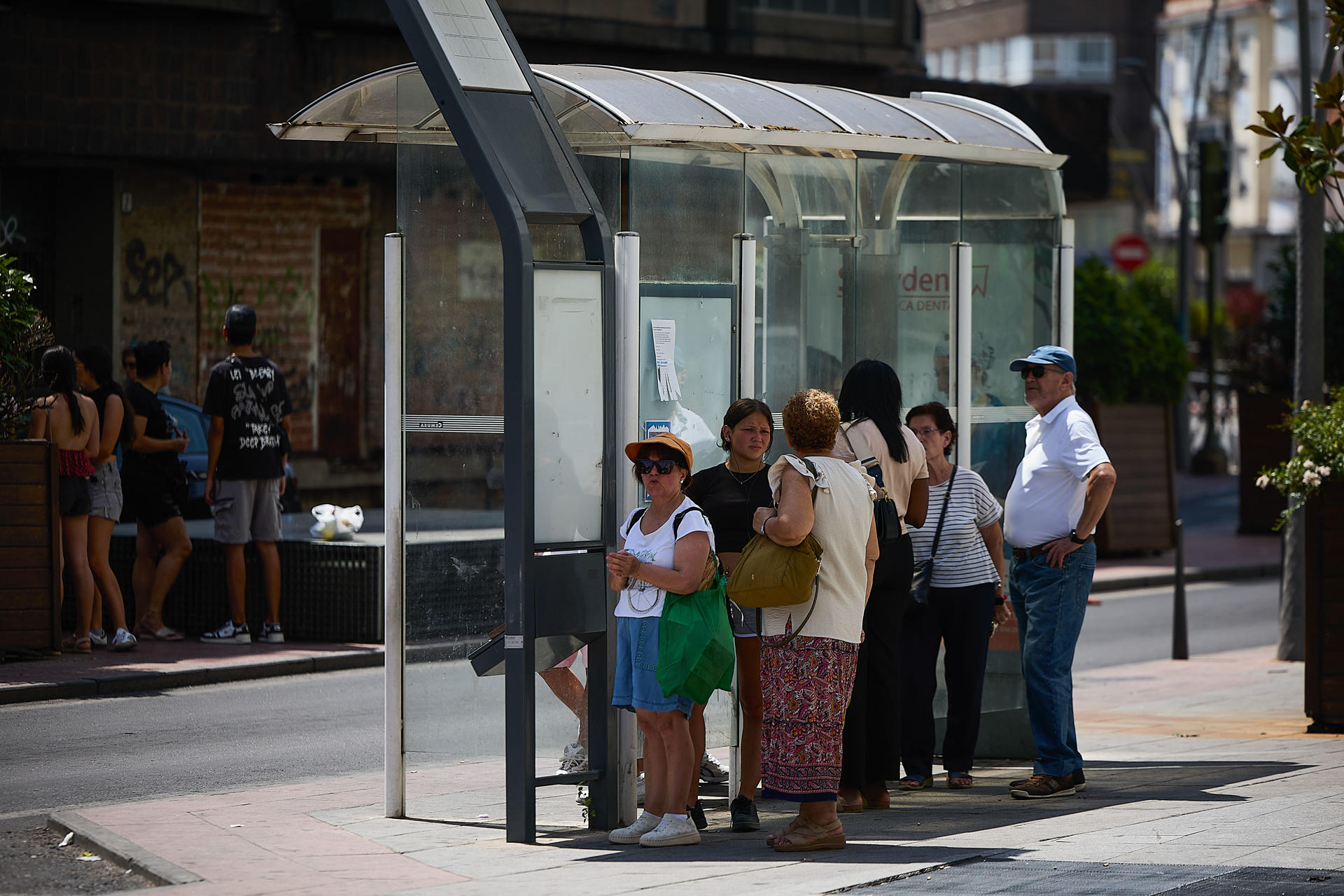 Unas personas esperan a un autobús a la sombra de una parada este miércoles en una terraza de la localidad toledana de Talavera de la Reina, que marcó ayer la temperatura máxima del país, 42,7 grados a las 18:20 horas. EFE/Manu Reino