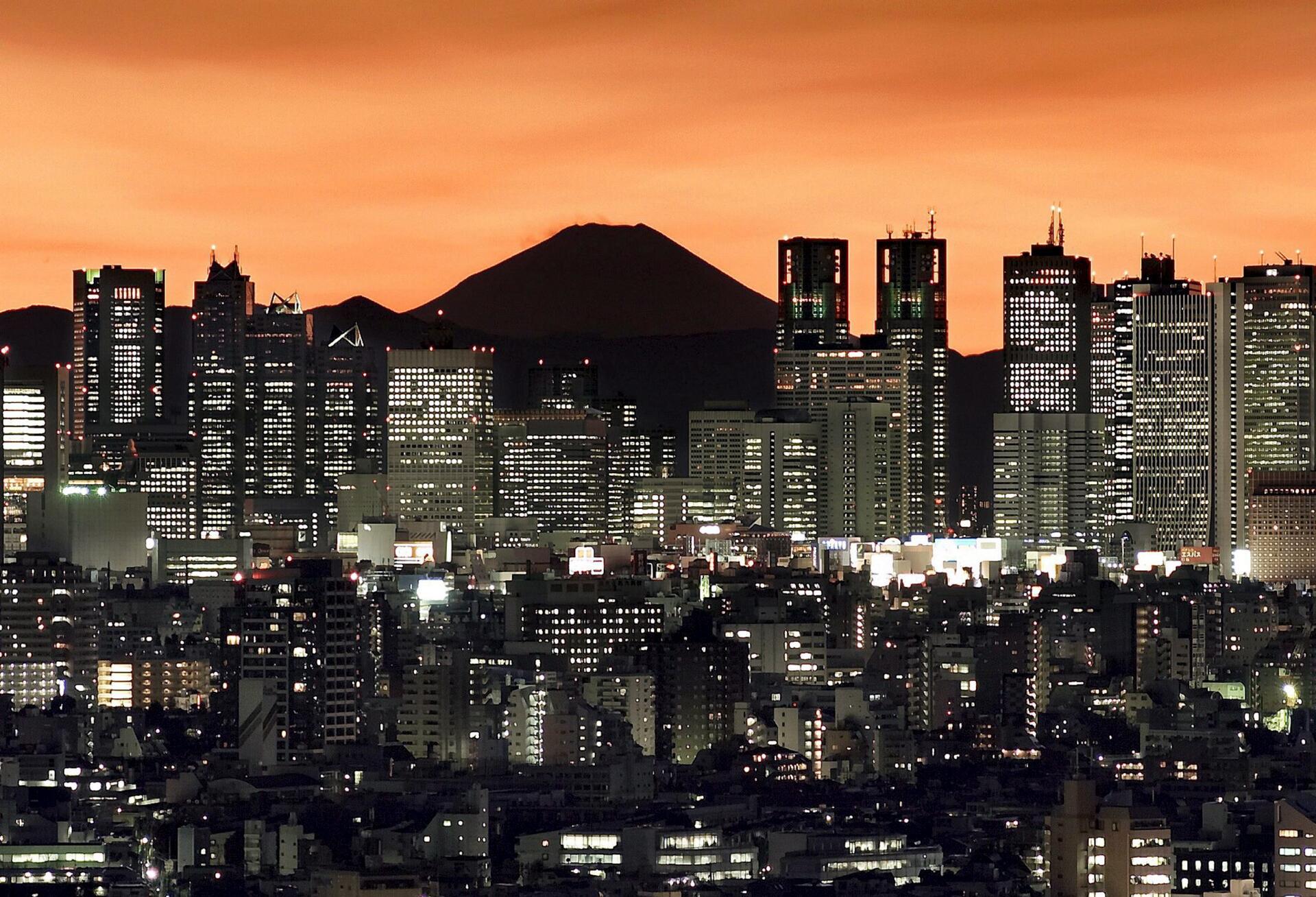 El pico del monte Fuji puede verse sobre los rascacielos Shinjuku en Tokio al amanecer el miércoles 27 de diciembre de 2006. EFE/ KIMIMASA MAYAMA/Archivo
