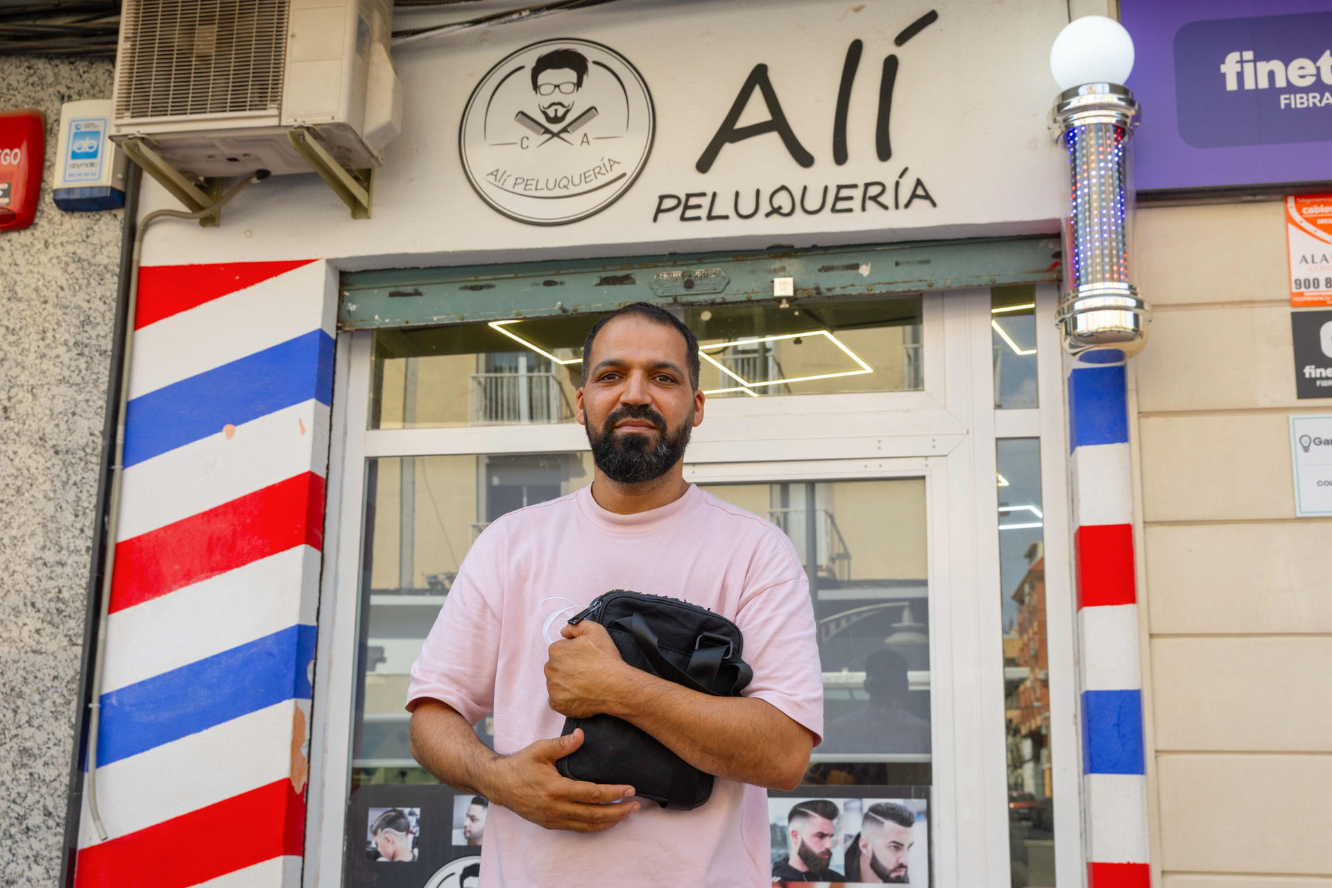 El barbero de origen marroquí Alí Houjja posa frente a sus barbería tras atender a la agencia Efe este viernes, en Jumilla (Murcia). Alí Houjja es marroquí, regenta una barbería del mismo nombre en la avenida del Levante de Jumilla, un área comercial situada a trescientos metros del centro, y llegó a España hace diecinueve años "precisamente en busca de libertad". En declaraciones a EFE este viernes en su local jumillano, en el que comparten butaca jóvenes marroquíes con clientes españoles, los más numerosos desde siempre, según explica, Alí Houjja es crítico con los partidos que fomentan el odio hacia los, migrantes porque la xenofobia lleva a la violencia y a delinquir, opina, y subraya que las fiestas religiosas musulmanas son parte de su identidad y siempre han sido respetadas en España. EFE/ Marcial Guillén
