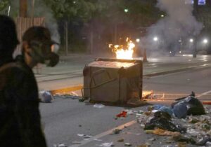 Manifestantes junto a un contenedor de basura volcado en llamas durante una protesta antigubernamental en Belgrado, Serbia, 15 de agosto de 2025. 
EFE/EPA/ANDREJ CUKIC
//////////
BELGRADE (Serbia), 16/08/2025.- Protesters walk past an overturned dumpster on fire during an anti-government protest in Belgrade, Serbia, 15 August 2025. Violent clashes broke out in Serbia this week between anti-government protesters, supporters of the ruling SNS party, and police. (Protestas, Belgrado) EFE/EPA/ANDREJ CUKIC