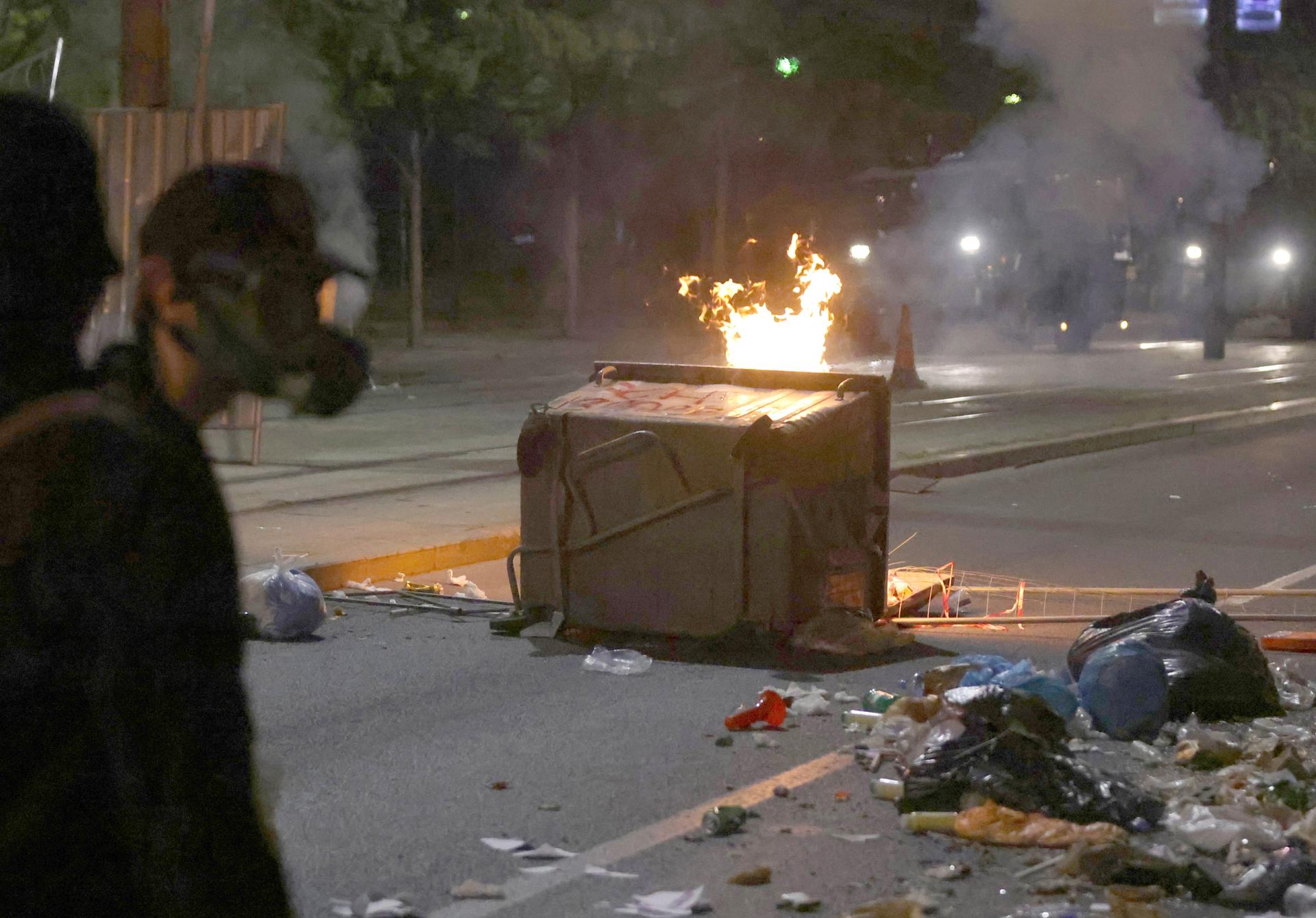 Manifestantes junto a un contenedor de basura volcado en llamas durante una protesta antigubernamental en Belgrado, Serbia, 15 de agosto de 2025. 
EFE/EPA/ANDREJ CUKIC
//////////
BELGRADE (Serbia), 16/08/2025.- Protesters walk past an overturned dumpster on fire during an anti-government protest in Belgrade, Serbia, 15 August 2025. Violent clashes broke out in Serbia this week between anti-government protesters, supporters of the ruling SNS party, and police. (Protestas, Belgrado) EFE/EPA/ANDREJ CUKIC