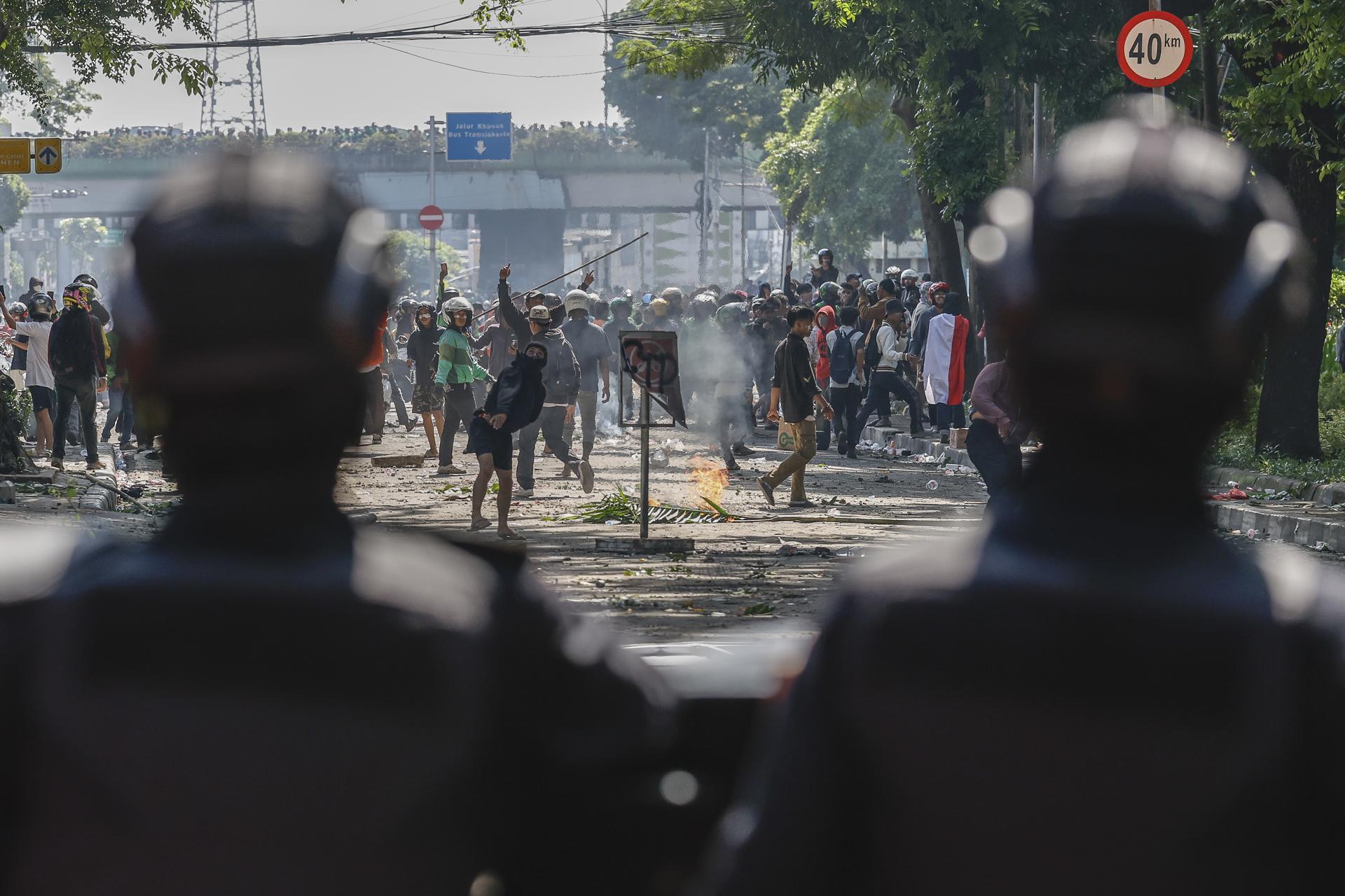 JAKARTA (Indonesia), 29/08/2025.- Police officers stand with their shields during clashes with protesters outside the Mobile Brigade police headquarters in Jakarta, Indonesia, 29 August 2025. Hundreds of protesters and motorbike-hailing drivers staged a protest following the death of a motorbike-hailing driver during an earlier demonstration against the housing allowance for members of parliament. (Protestas) EFE/EPA/MAST IRHAM