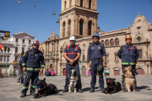 Integrantes de la Segunda Compañía de Bomberos Santa Bárbara fueron captados este jueves, 7 de agosto, al posar junto a perros entrenados en búsqueda y rescate de humanos bajo escombros, en La Paz (Bolivia). EFE/Esteban Biba