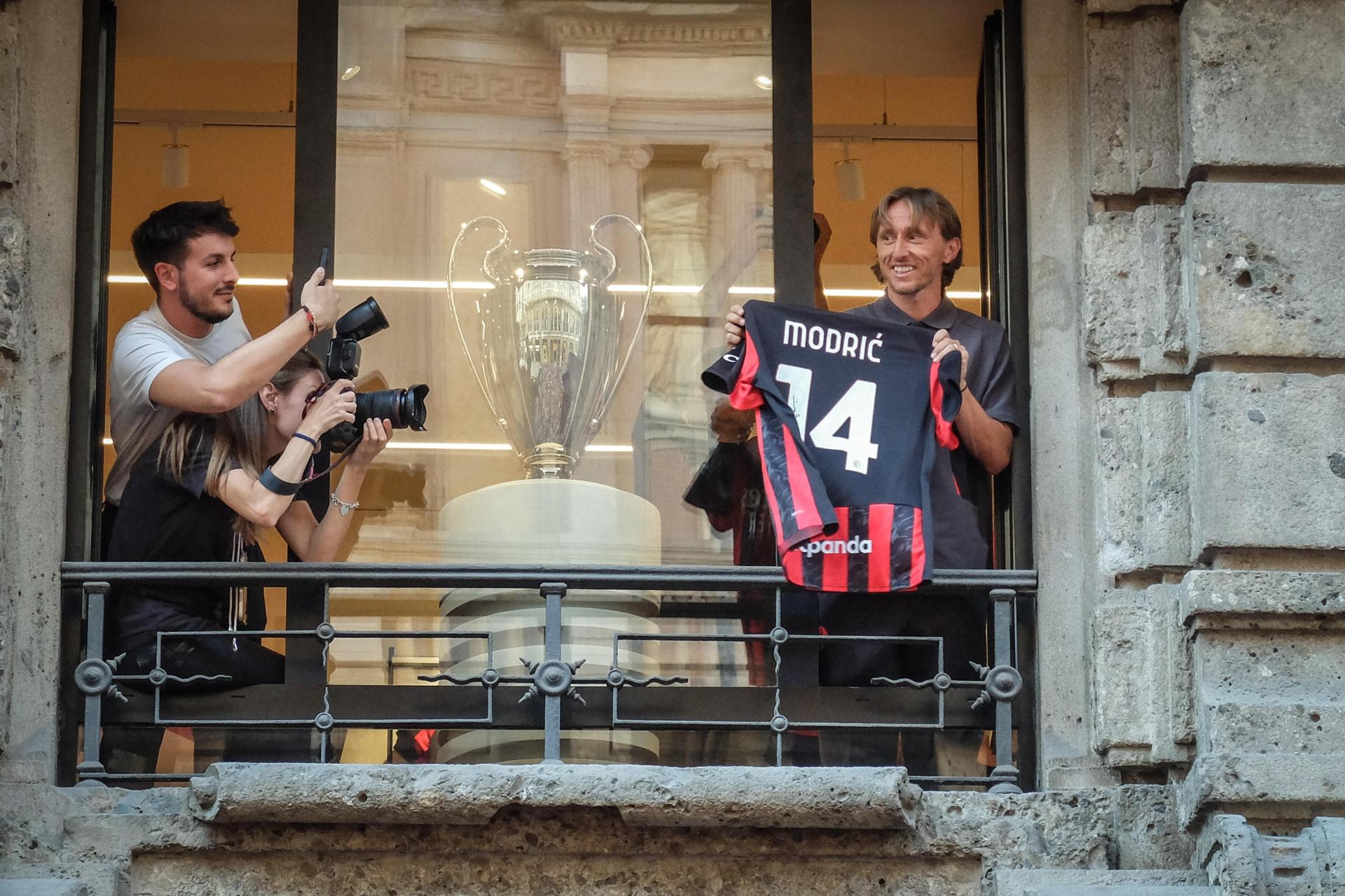 El croata Luka Modric saluda a los aficionados del Milan con una camiseta del equipo desde la tienda oficial del club "rossonero". EFE/MATTEO CORNER