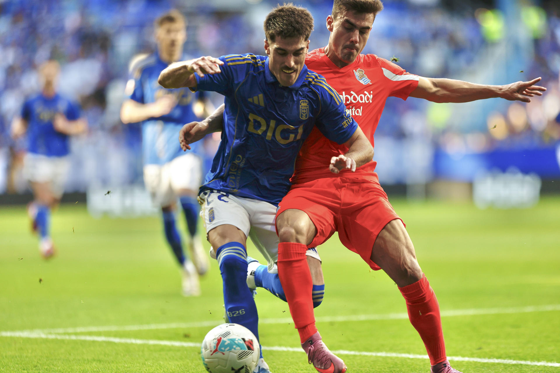 El defensa del Oviedo Nacho Vidal (i) lucha con Ander Barrenetxea, de la Real Sociedad, en el partido de LaLiga entre el Real Oviedo y la Real Sociedad, este sábado en el estadio Carlos Tartiere. EFE/Paco Paredes