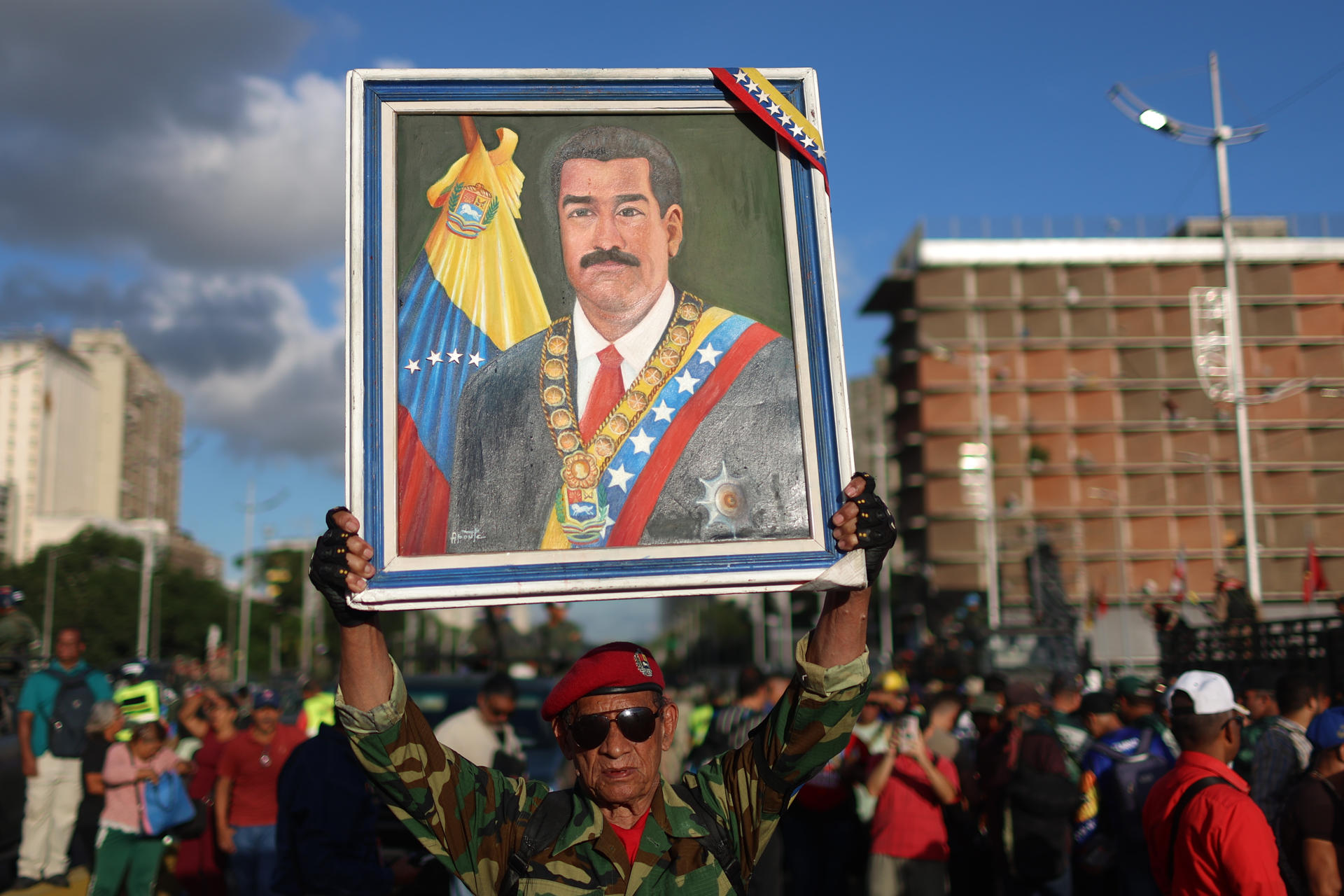 Un hombre sostiene un cuadro con la imagen del presidente de Venezuela, Nicolás Maduro, durante un ejercicio militar este martes, en Caracas (Venezuela). EFE/ Miguel Gutierrez