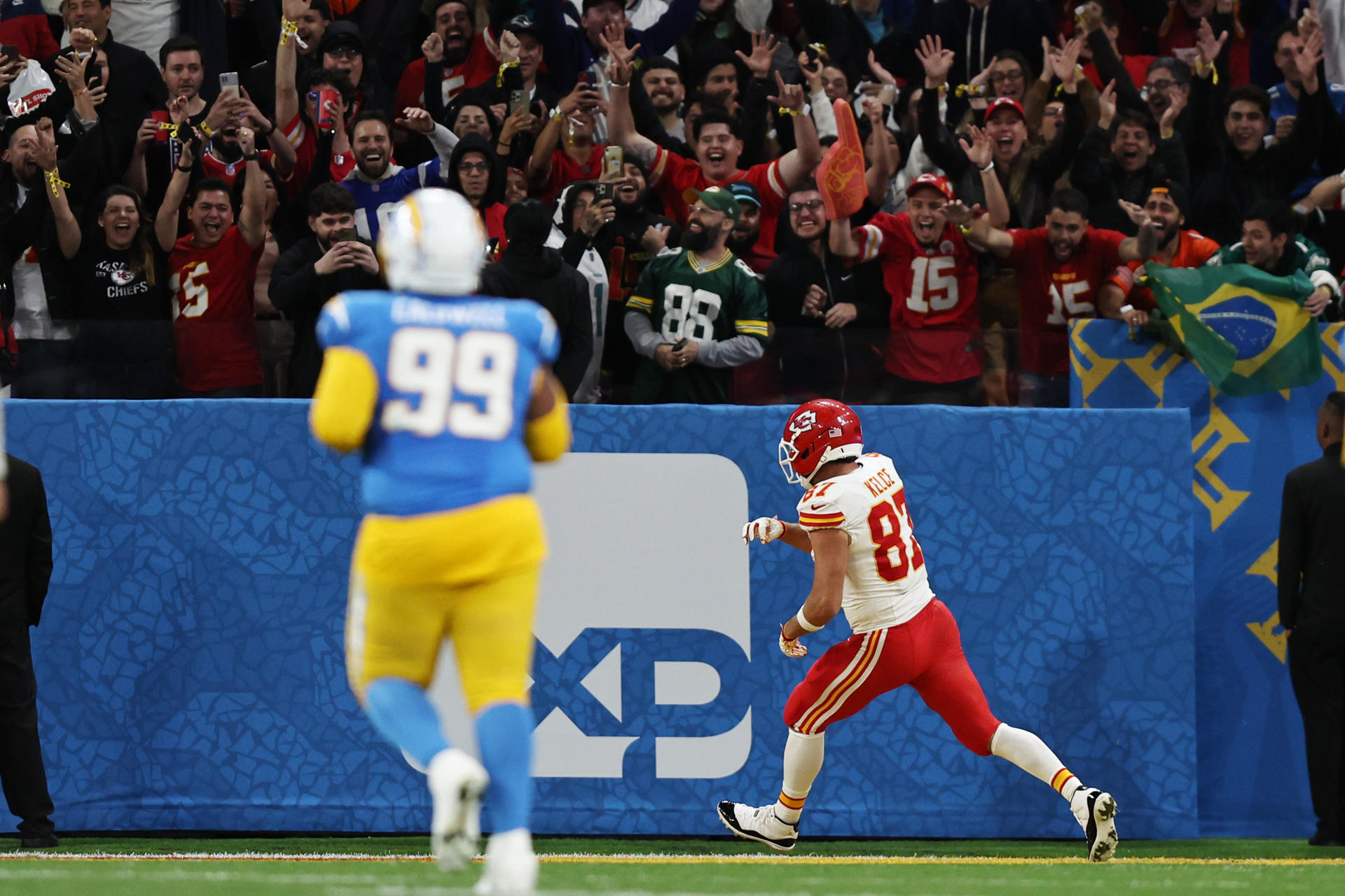 Travis Kelce (d), de los Chiefs, avanza con el balón en un partido de la NFL entre Los Ángeles Chargers y Kansas City Chiefs en el estadio Neo Química Arena en São Paulo (Brasil). EFE/Isaac Fontana
