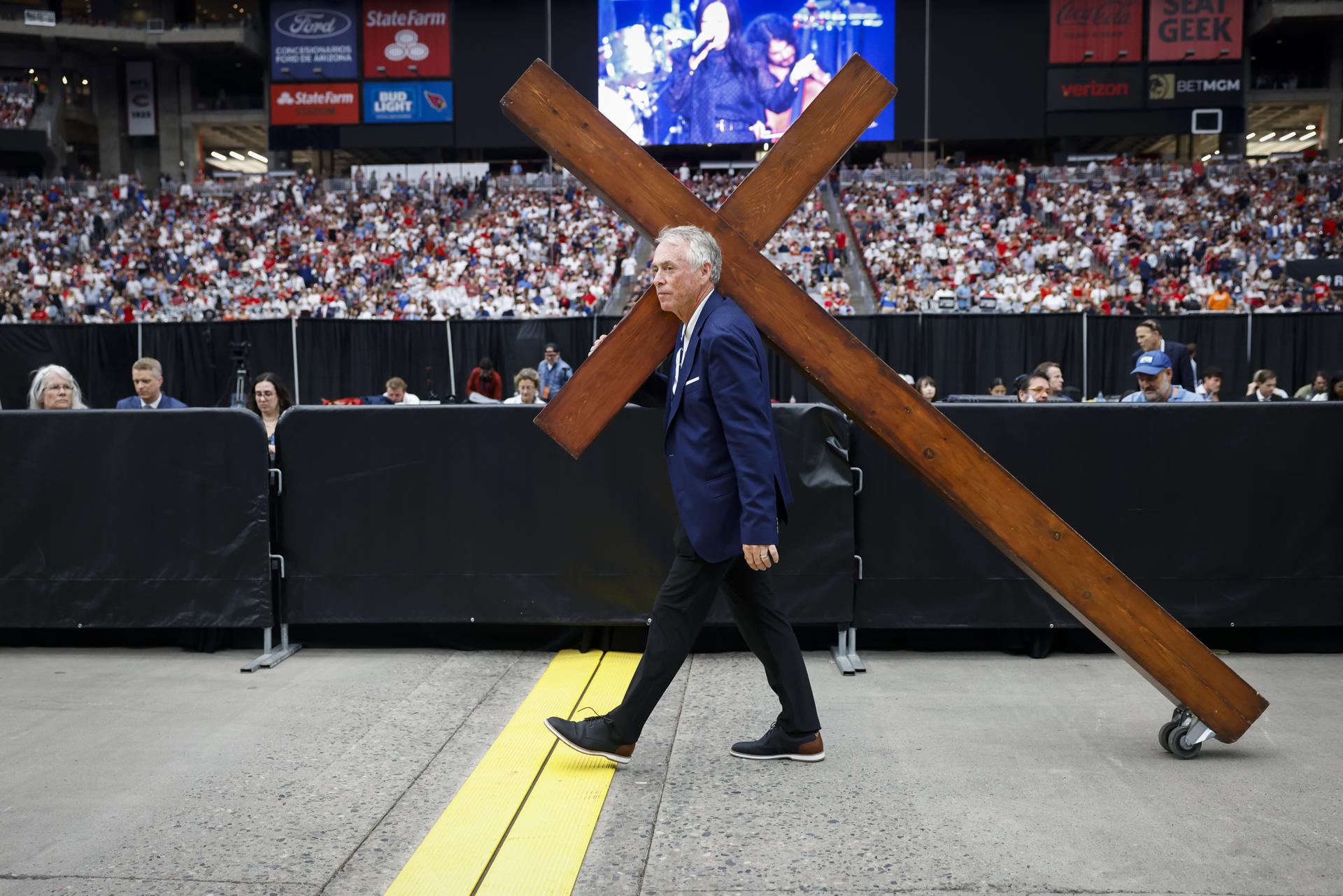 Dan Beasley lleva una cruz de madera por el estadio State Farm antes del servicio conmemorativo público por el activista político Charlie Kirk en Glendale, Arizona, EE. UU. EFE/CAROLINE BREHMAN
