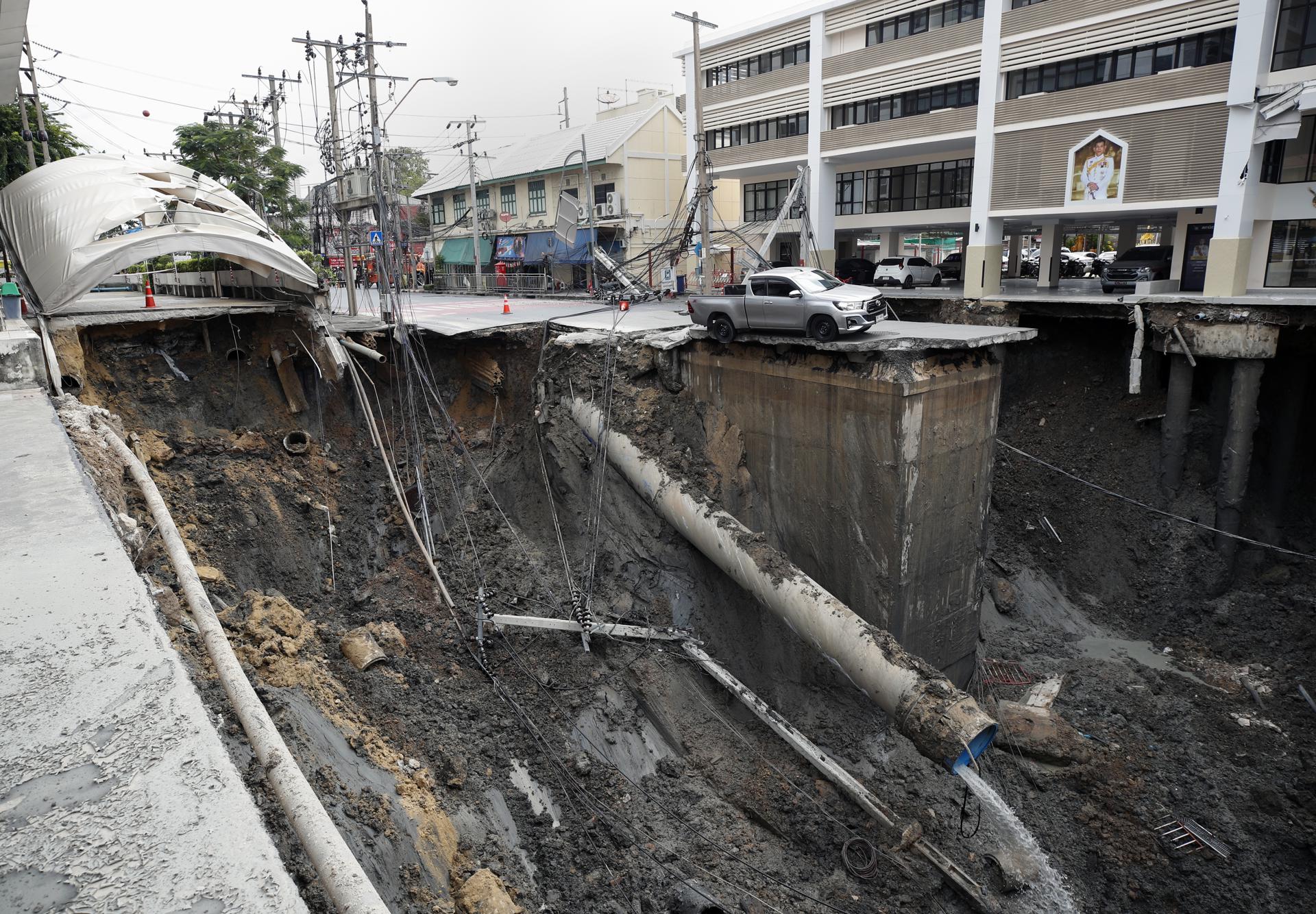 Bangkok (Thailand), 24/09/2025.- A vehicle is stuck in a large hole in front of Samsen police station following a road collapse in Bangkok, Thailand, 24 September 2025. A major street in Bangkok's Samsen district collapsed, creating a hole about 50 meters deep, 30 meters wide, and 30 meters long, but no injuries were reported. (Tailandia) EFE/EPA/RUNGROJ YONGRIT
