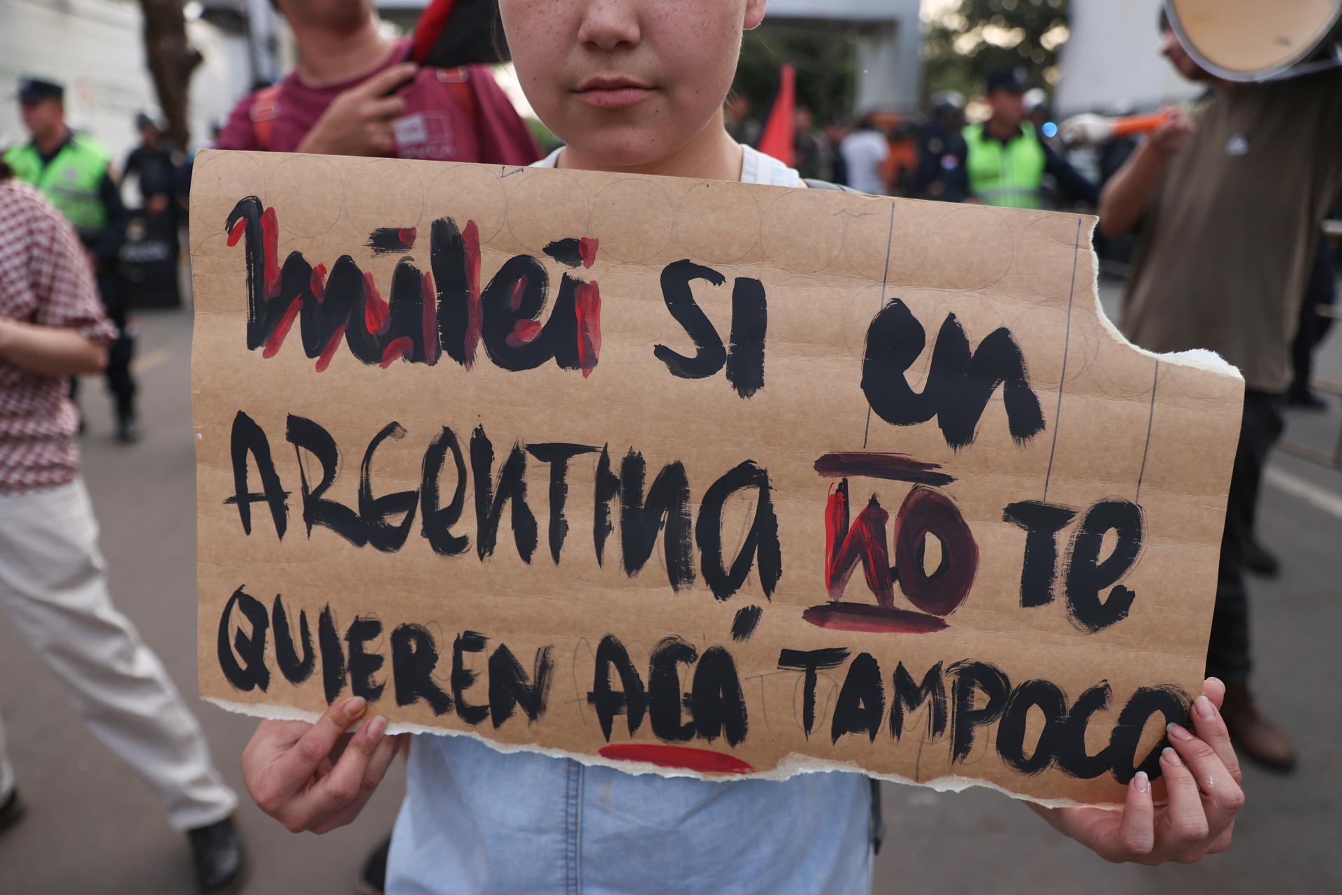 Una persona sostiene un cartel durante una manifestación contra la participación del presidente de Argentina, Javier Milei, en el Foro de Emprendedores Industriales de Paraguay FEIP 2025 este martes, frente a la Secretaría Nacional de Deportes, en Asunción (Paraguay). EFE/ Juan Pablo Pino