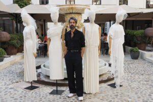 El diseñador Moisés Nieto posa junto a algunas de sus creaciones durante la presentación de su colección cápsula de vestidos de novia parte de Madrid es Moda, este lunes en Madrid. EFE/Sergio Pérez