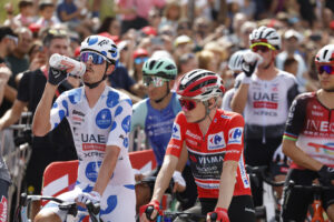 El líder de la clasificación general, el danés Jonas Vingegaard (c), del equipo Visma-Lease a Bike, junto al líder de la Montaña, el australiano Jay Vine (i), del equipo UAE Team Emiates, antes de darse la salida de la vigésima etapa de La Vuelta a España disputada este sábado entre las localidades madrileñas de Robledo de Chabela y el Puerto de Navacerrada con un recorrido de 165.6 km. EFE/ Javier Lizón