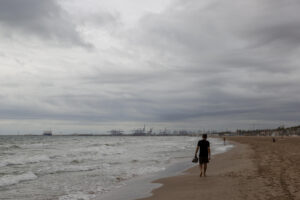 Una persona aguarda en la playa de la Patacona durante este martes en el que la Comunitat Valenciana afronta por segundo día una situación meteorológica adversa, con alerta naranja en el litoral de Alicante y el interior, además del litoral sur de Valencia, en donde las acumulaciones por lluvia serían de hasta 40 l/m2 en una hora, mientras en el litoral norte de Alicante se podrán acumular en doce horas hasta 100 l/m2. EFE/Manuel Bruque