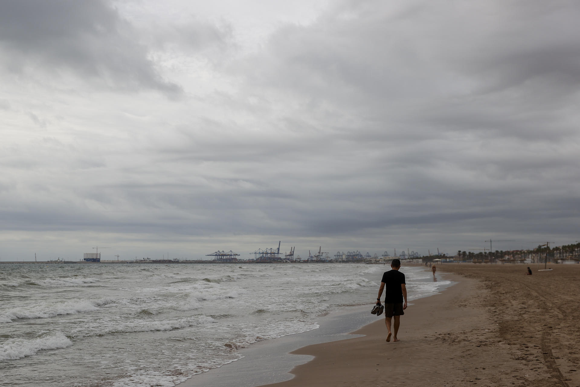 Una persona aguarda en la playa de la Patacona durante este martes en el que la Comunitat Valenciana afronta por segundo día una situación meteorológica adversa, con alerta naranja en el litoral de Alicante y el interior, además del litoral sur de Valencia, en donde las acumulaciones por lluvia serían de hasta 40 l/m2 en una hora, mientras en el litoral norte de Alicante se podrán acumular en doce horas hasta 100 l/m2. EFE/Manuel Bruque