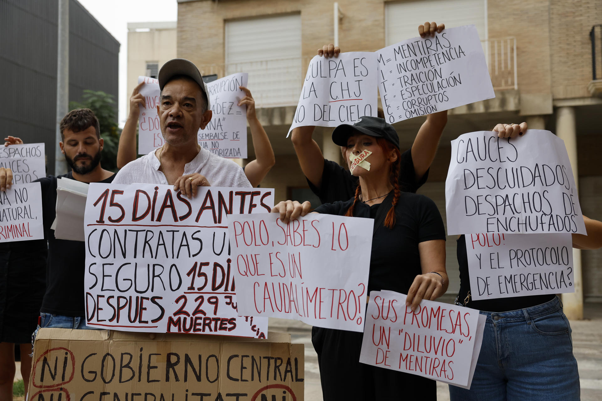 Varias personas protestan ante los juzgados de Catarroja (Valencia), donde este viernes declara como testigo el presidente de la Confederación Hidrográfica del Júcar (CHJ), Miguel Polo, ante la jueza que instruye la causa penal sobre la dana para responder a las preguntas de decenas de letrados sobre las horas más trágicas de las riadas del pasado 29 de octubre. EFE/Ana Escobar
