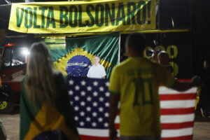 Simpatizantes del expresidente de Brasil Jair Bolsonaro sostienen una bandera de Estados Unidos durante una vigilia de oración en apoyo al exmandatario este jueves, en Brasilia (Brasil). EFE/ Antonio Lacerda