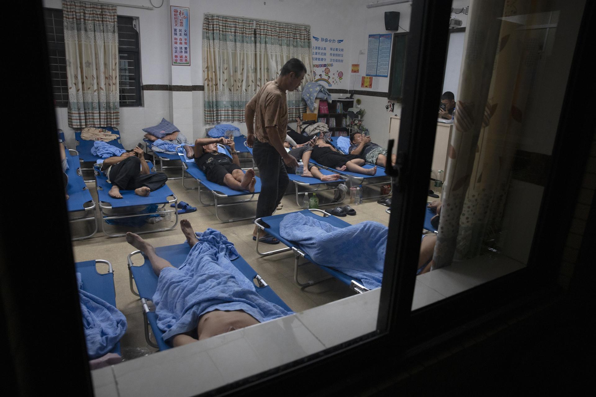 MAOMING (China), 24/09/2025.- La gente descansa en un sitio de reasentamiento temporal establecido dentro de la escuela primaria Bomei en la ciudad de Bohe, en medio del paso del tifón Ragasa en Maoming, provincia de Guangdong, China. EFE/EPA/ANDRES MARTINEZ CASARES
