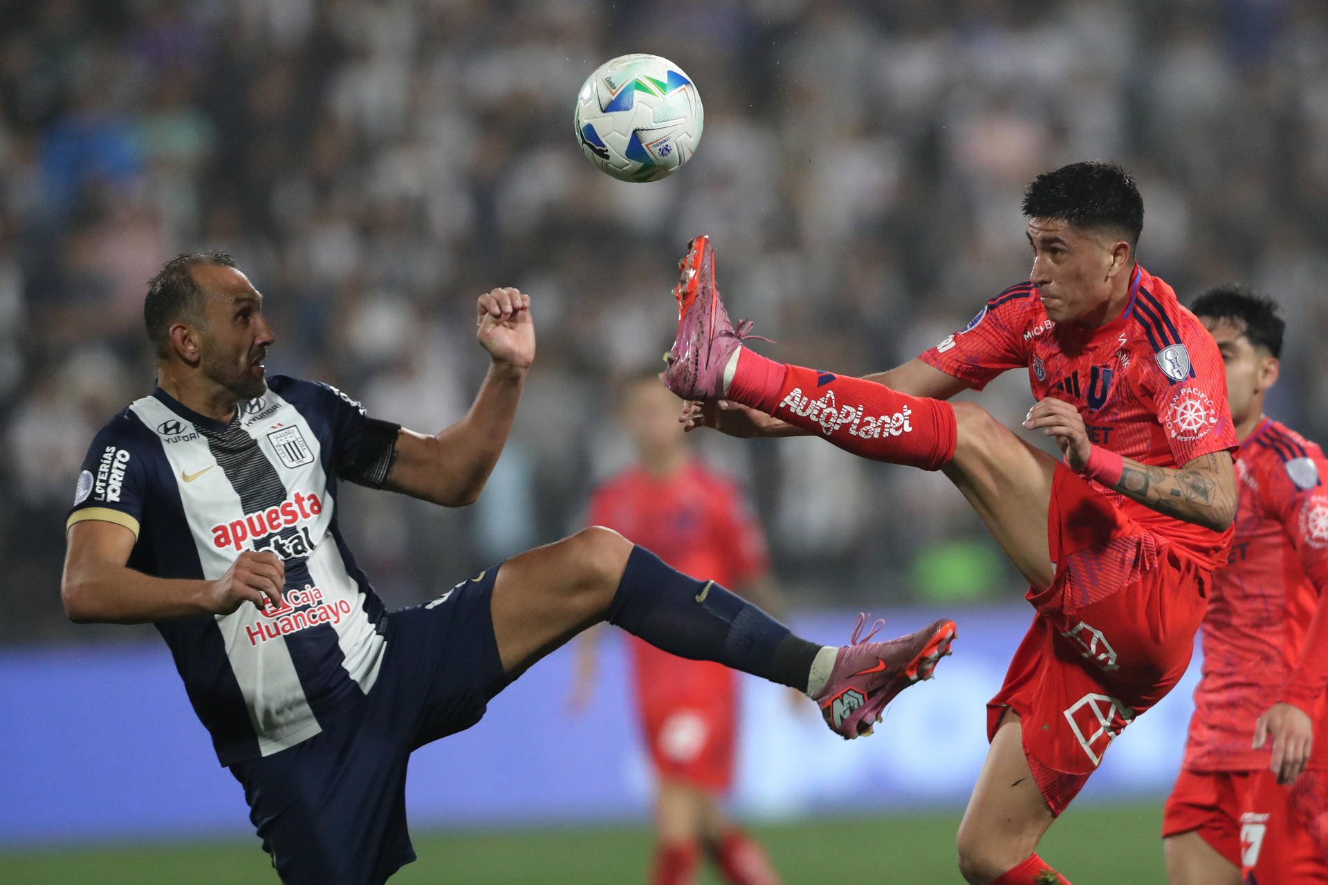 Hernán Barcos (i), de Alianza Lima, disputa el balón este jueves en el partido de cuartos de final de la Copa Sudamericana ante Universidad de Chile en el estadio Alejandro Villanueva. EFE/ Paolo Aguilar
