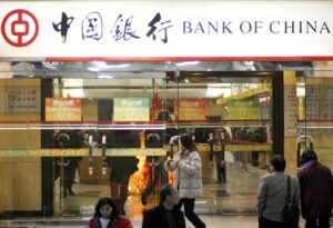 Personas caminan en Shanghái delante de un edificio con un cartel de Bank of China. EPA/QILAI SHEN  Qilai Shen[Qilai Shen]