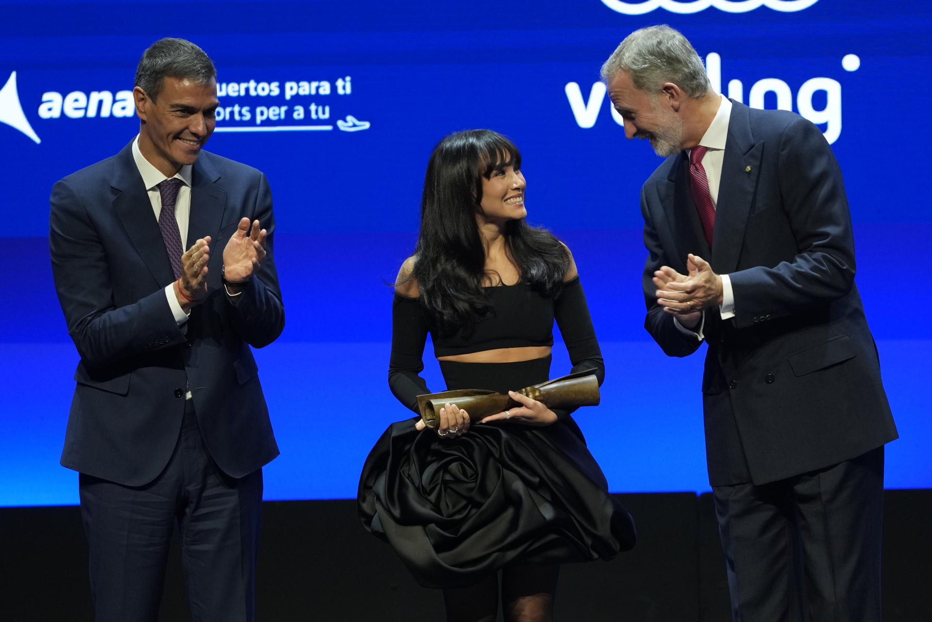 La cantante Aitana recibe el Premio Cultura, acompañada por el rey Felipe VI (d) y por el presidente del Gobierno Pedro Sánchez (i), durante la gala de los Premios Vanguardia que se celebran este lunes en el Palau de Congressos de Catalunya, en Barcelona. EFE/Alejandro García
