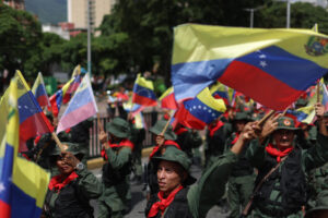 Personas sostienen banderas durante un ejercicio militar este martes, en Caracas (Venezuela). EFE/ Miguel Gutiérrez