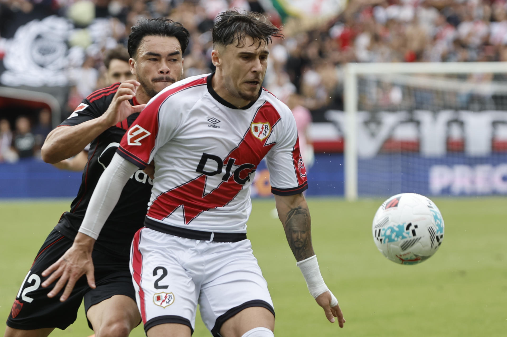 Suazo (i), del Sevilla, lucha por la posesión del balón con Andrei (d), del Rayo Vallecano, durante el partido correspondiente a la jornada 7 de LaLiga disputado este domingo en el Estadio de Vallecas. EFE/ Sergio Pérez