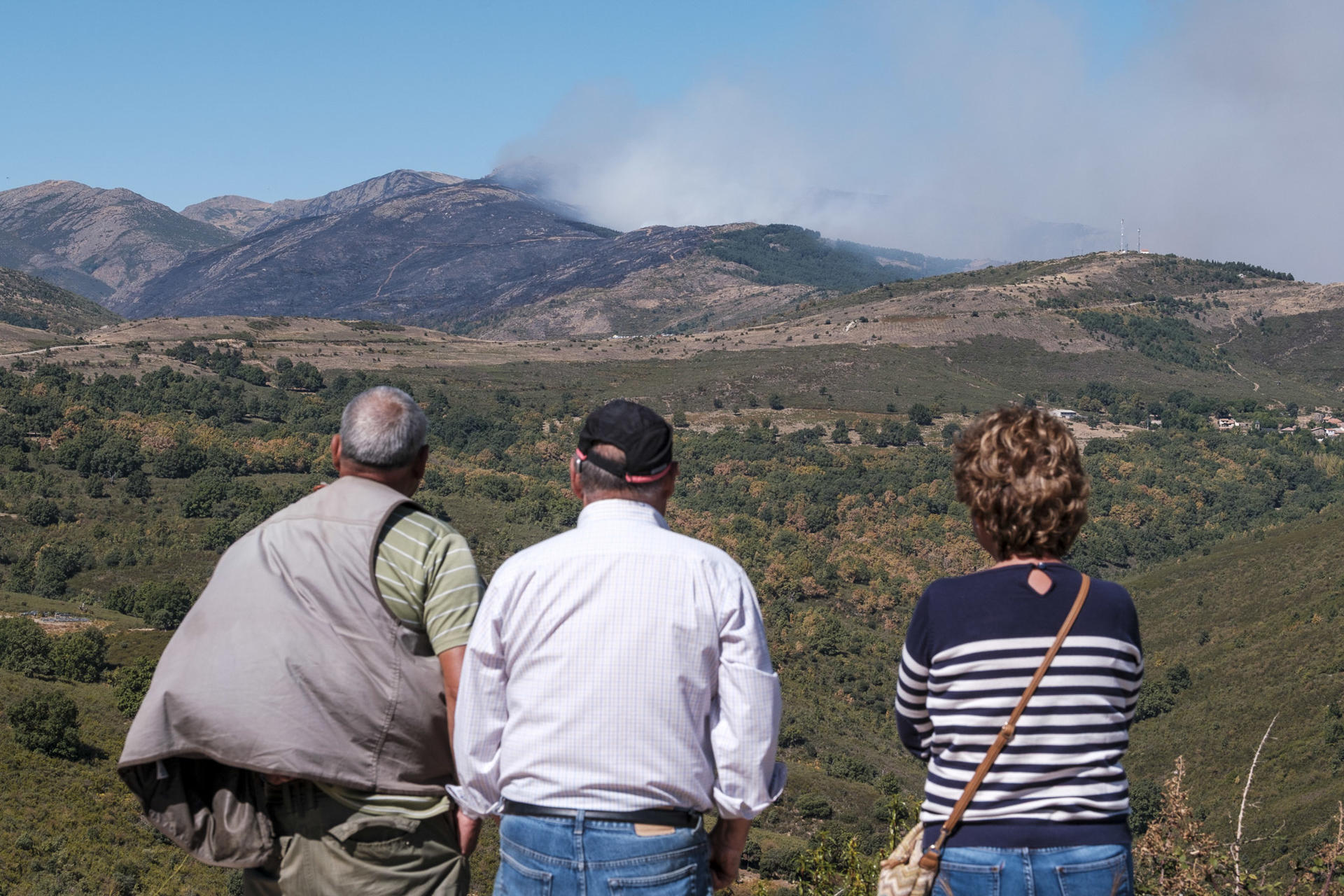 Varias personas observan la evolución del incendio declarado en la zona de Pico del Lobo. EFE/ Nacho Izquierdo
