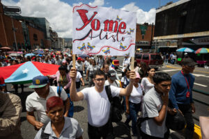 Un hombre sostiene un cartel durante una marcha en respaldo al presidente de Venezuela, Nicolás Maduro, este viernes en Caracas (Venezuela). EFE/ Ronald Peña