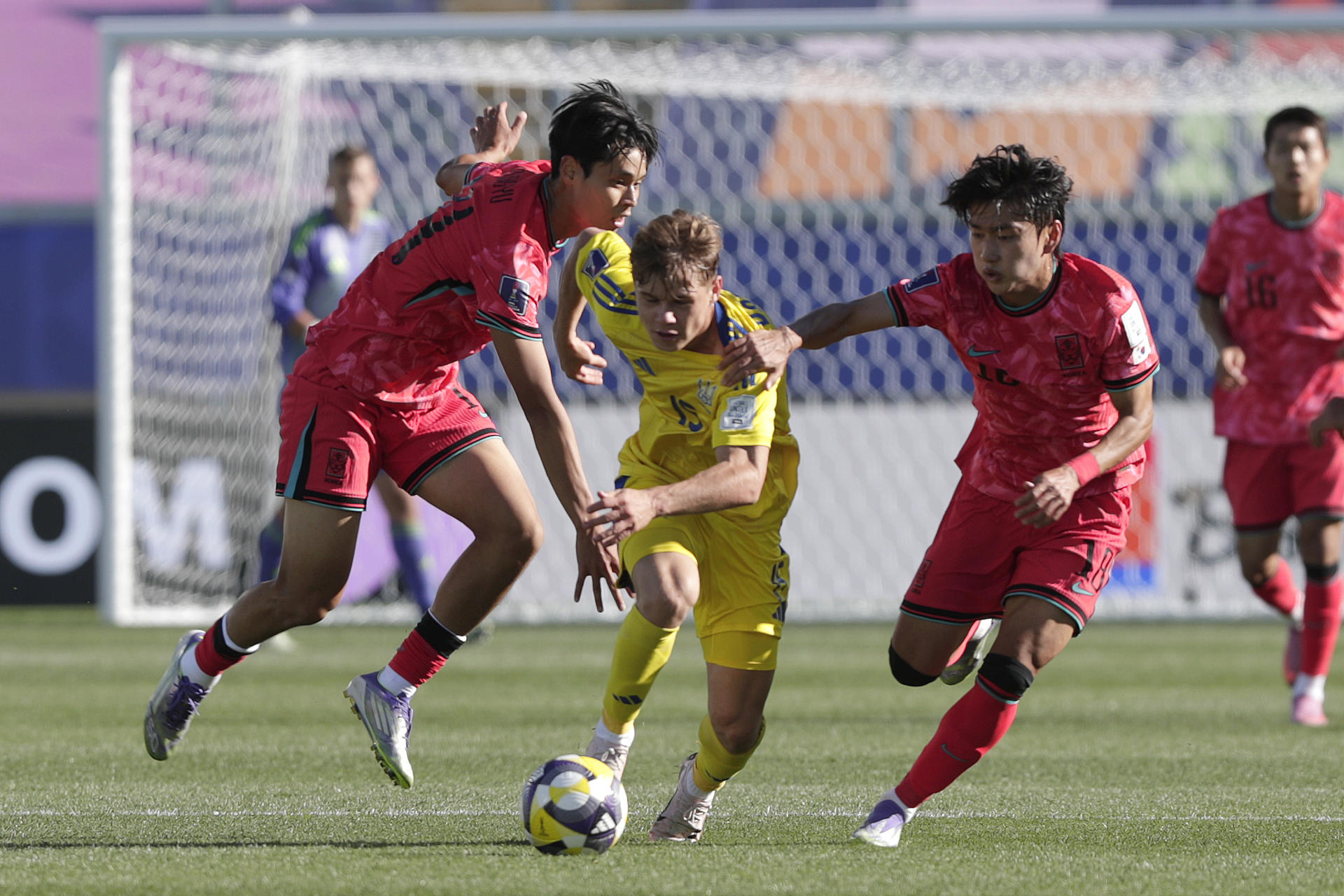 Sun-Woo (i) y Byung-Wook (d), de Corea del Sur, disputan el balón con Hennadiy Synchuk, de Ucrania, en partido del grupo B del Mundial Sub-20 en Valparaíso (Chile). EFE/Adriana Thomasa
