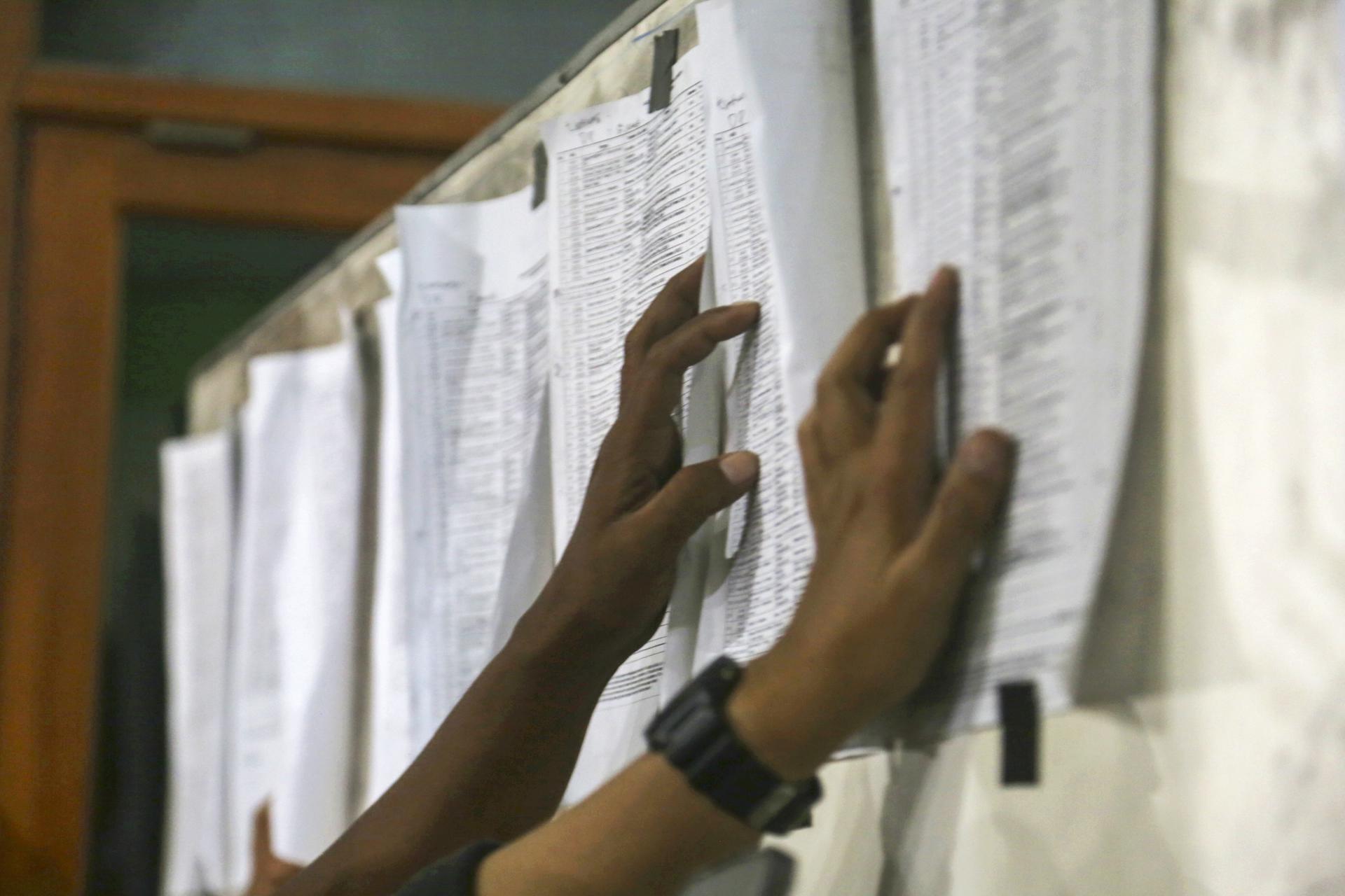 Dos personas revisan la lista de rescatados tras el derrumbe de un internado un Indonesia.
EFE/EPA/FULLY HANDOKO
