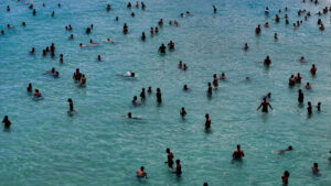 Fotografía aérea de personas bañándose en el agua del mar en la playa de Macumba, en Río de Janeiro (Brasil). EFE/ Antonio Lacerda
