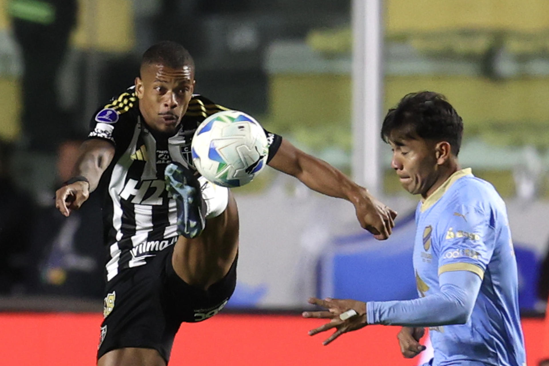 Caio Paulista (i), de Mineiro, disputa el balón con Jesús Sagredo, de Bolívar, en un partido por los cuartos de final de la Copa Sudamericana entre Bolívar y Atlético Mineiro en el estadio Hernando Siles Reyes, en La Paz (Bolivia). EFE/ Luis Gandarillas
