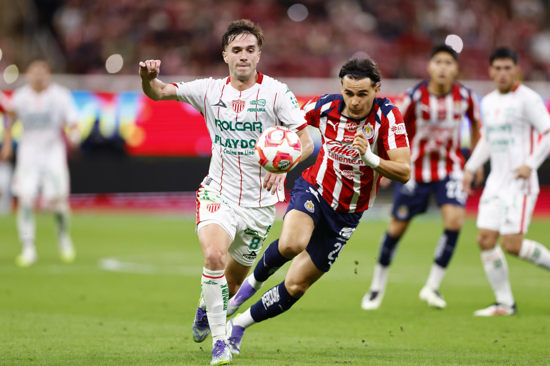 Teun Wilke (d), del Guadalajara, disputa el balón con Agustin Palavecino, del Necaxa, este martes en un partido de la Liga MX en el estadio Akron. EFE/ Francisco Guasco
