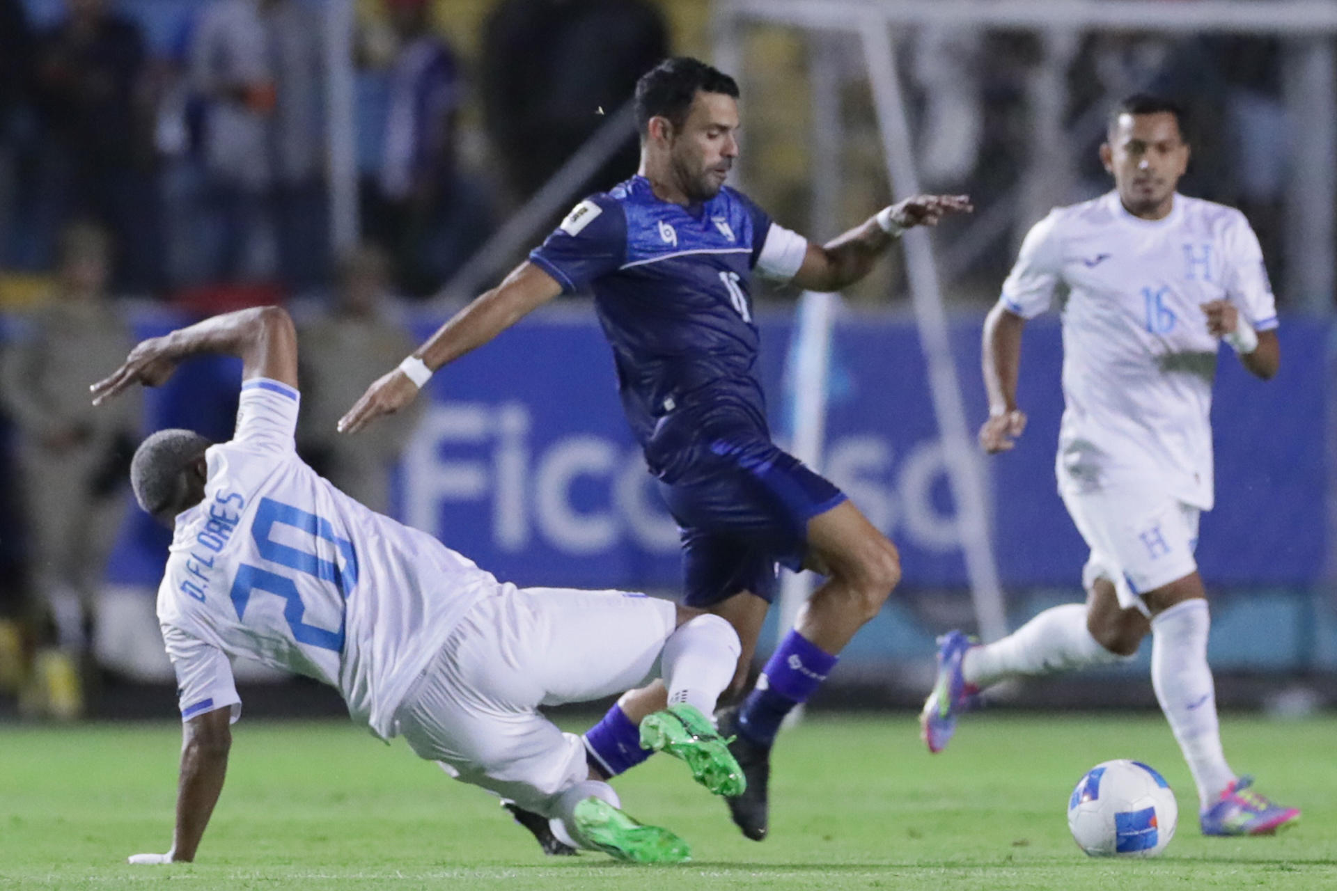 El hondureño Deybi Flores (i) sale al corte del delantero nicaragüense Juan Barrera durante el partido de las eliminatorias de la Concacaf para el Mundial de 2026 jugado este martes en el estadio José de la Paz Herrera, de Tegucigalpa. EFE/ Gustavo Amador
