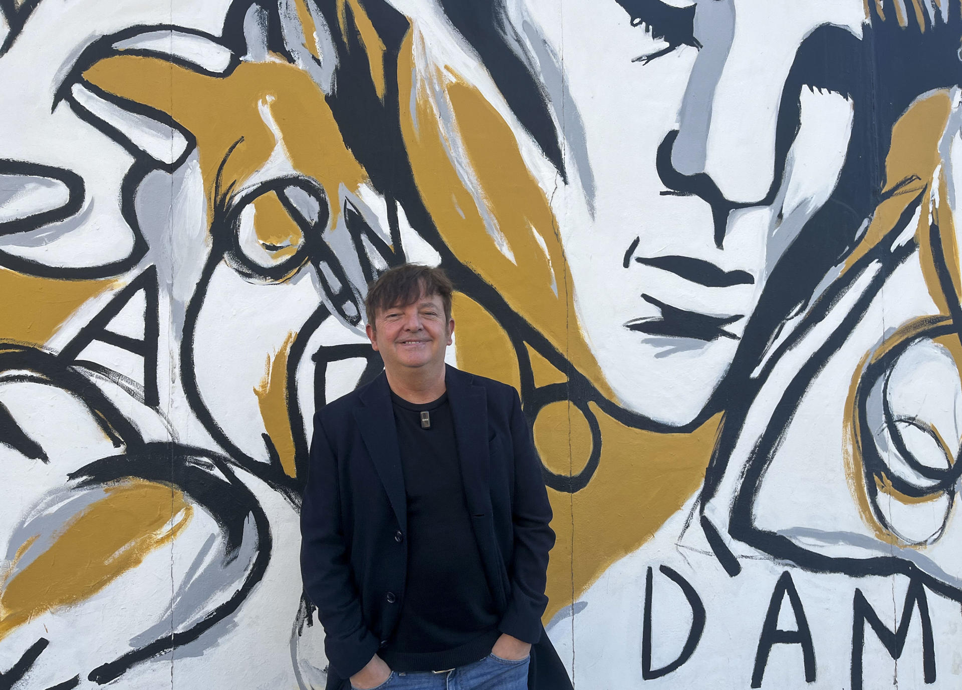 El artista español Ignasi Blanch pintó 'Parlo d'amor' (Hablo de amor) en la East Side Gallery, la sección del muro de Berlín cubierto con coloridos murales que cumple 35 años, con la idea inicial de que fuera un proyecto efímero, pero se ha convertido en un legado cultural que perdura en el tiempo. En su mural, Blanch asegura a EFE que habla de "diversidad, de la libertad, llamar a quien quieras de un modo libre y con tranquilidad", pero asegura que esto sigue siendo delito en muchos países y que es un tema "de moda" por "lo difícil que es otra vez". EFE/ Andrea Gallego