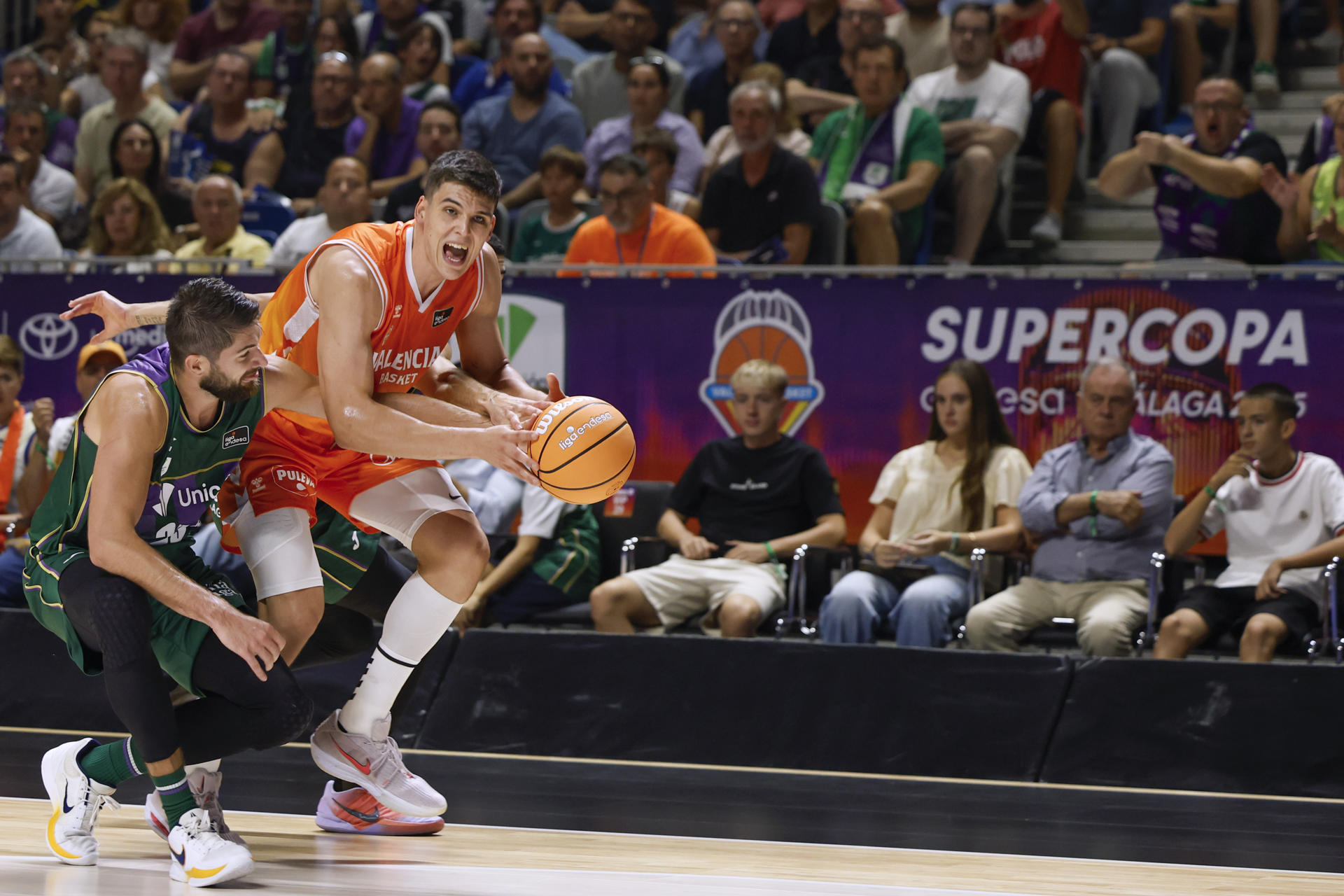 El ala-pivot de Valencia Basket, Jaime Pradilla (d), con el balón ante el ala-pivot francés de Unicaja, Killian Tillie, durante el encuentro correspondiente a la primera semifinal de la Supercopa que disputaron Unicaja y Valencia Basket en el pabellón Martín Carpena, en Málaga. EFE / Jorge Zapata.
