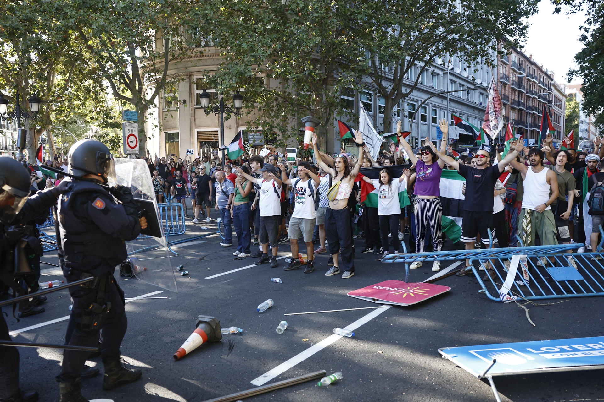 Los manifestantes propalestinos cortan el recorrido de los ciclistas en el Paseo del Prado, este domingo, durante la última etapa de la Vuelta a España que se disputa entre las localidades madrileñas de Alalpardo y Madrid, con un recorrido 103,6 Km.- EFE/Rodrigo Jiménez