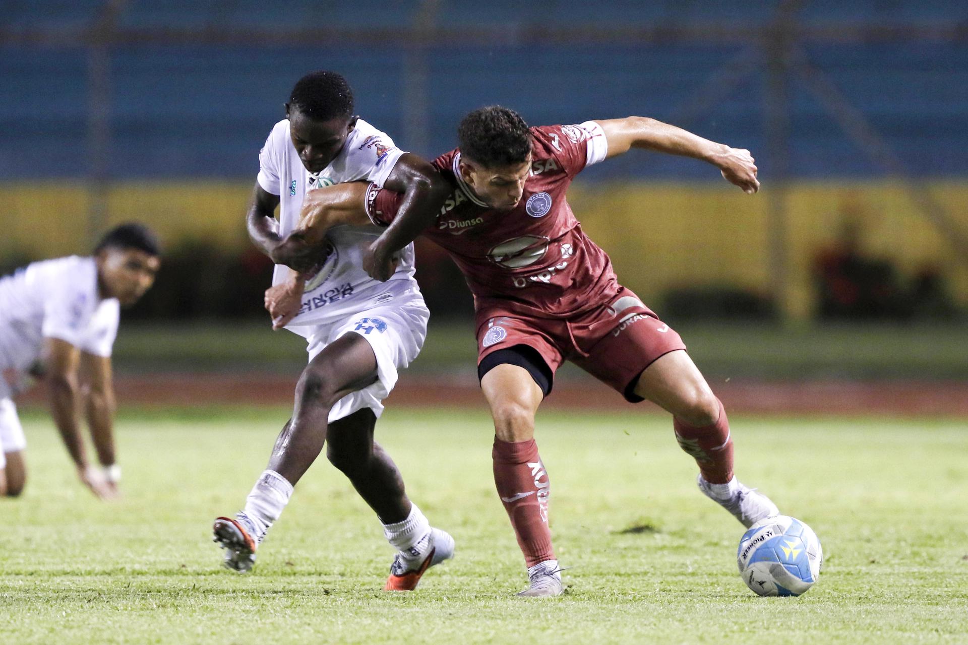 Jason Arriola (i) de Platense disputa el balón con Marcelo Santos de Motagua este miércoles en un partido de la Liga Nacional de Fútbol de Honduras en el estadio Olímpico de San Pedro Sula. EFE/José Valle
