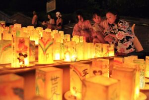 Varios niños observan farolillos colocados para recordar a las víctimas del ataque con bomba atómica de Estados Unidos a la ciudad de Nagasaki, lo que provocó la rendición de Japón el 2 de septiembre de 1945. EFE/Kimimasa Mayama/ Archivo
