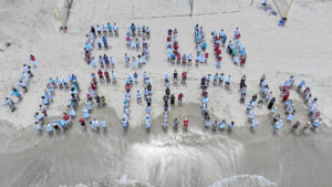 Fotografía cedida por las organizaciones Kilómetro 0, Amnistía Internacional de Puerto Rico, Comuna Caribe y la Unión Americana de Libertades Civiles (ACLU, en Inglés) que muestra a personas formando durante una manifestación este sábado, en la playa balneario de Carolina (Puerto Rico). EFE/ Kilómetro 0/ Amnistía Internacional de Puerto Rico/ Comuna Caribe/ACLU