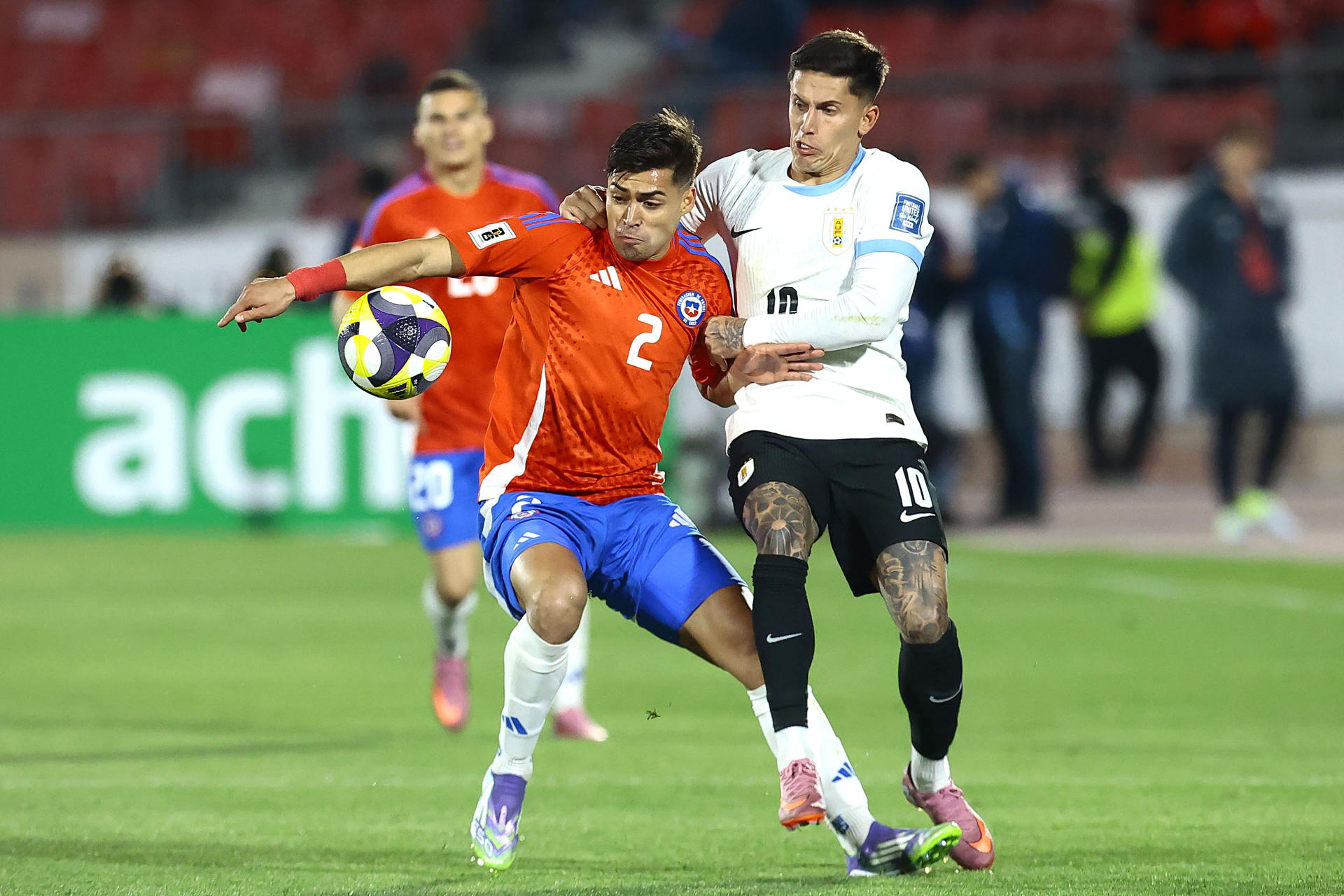 Fabián Hormazábal, de Chile (i), disputa el balón con Brian Rodríguez, de Uruguay, en un partido por las eliminatorias a la Copa Mundial 2026 entre Chile y Uruguay en el estadio Julio Martínez Prádanos, en Santiago (Chile). EFE/ Osvaldo Villarroel