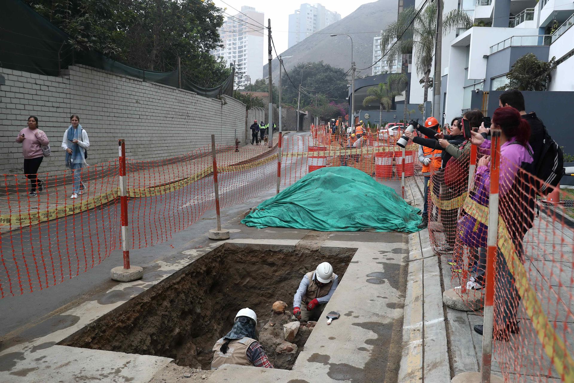 Personas limpian piezas antiguas y restos óseos este miércoles, en Lima (Perú). EFE/ Paolo Aguilar