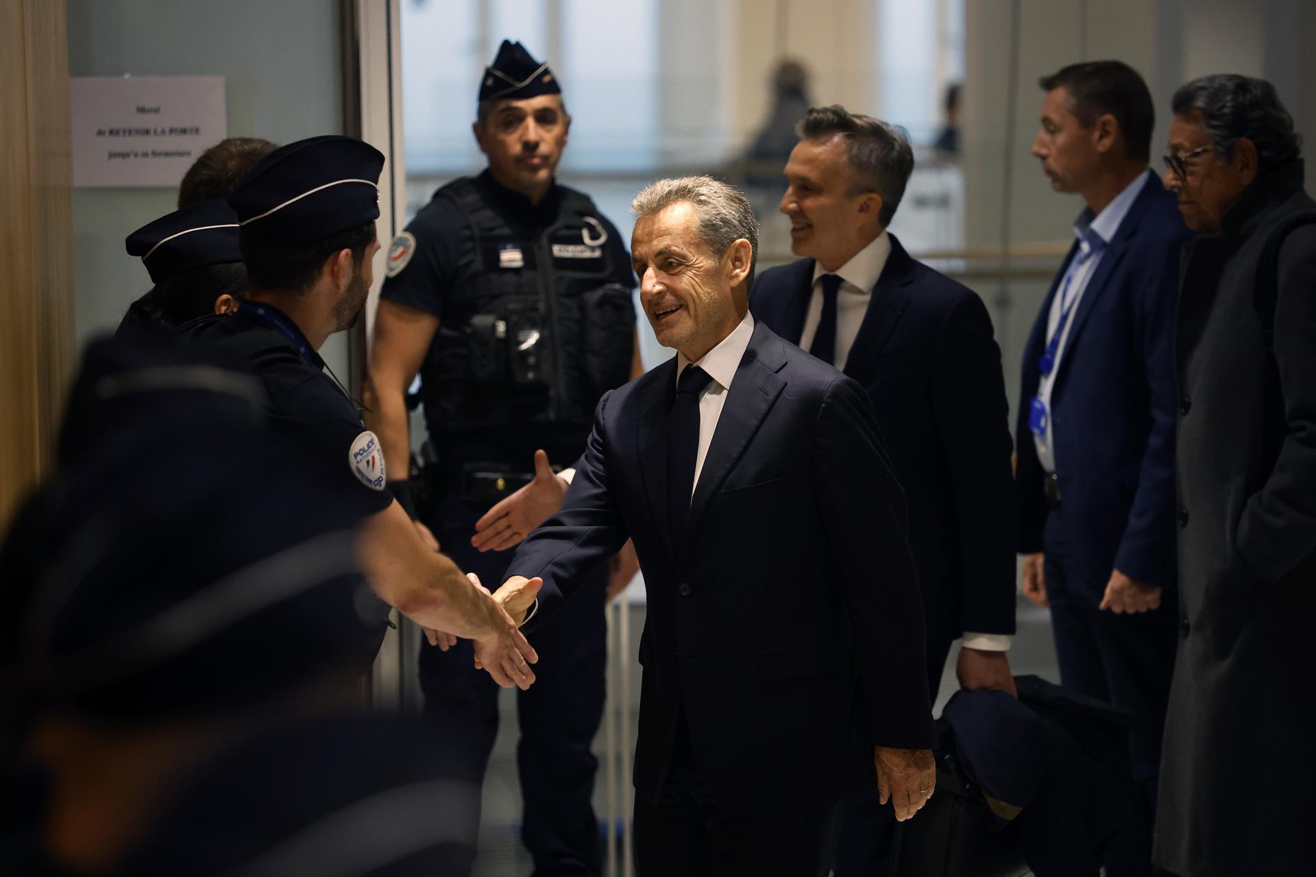 El expresidente francés Nicolas Sarkozy saluda a agentes en el Tribunal Correccional de París. EFE/EPA/Teresa Suarez
